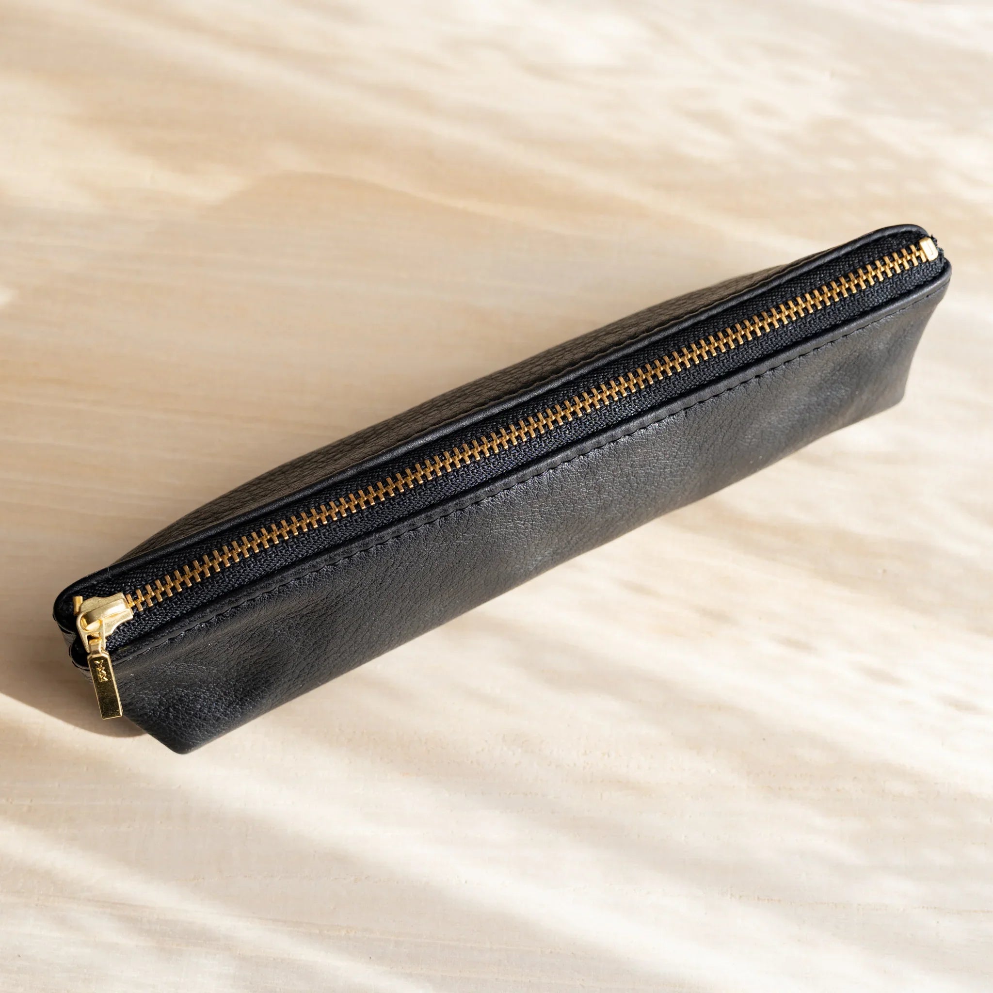 Leather pen case shown with pens inside displaying storage function and features and features and features