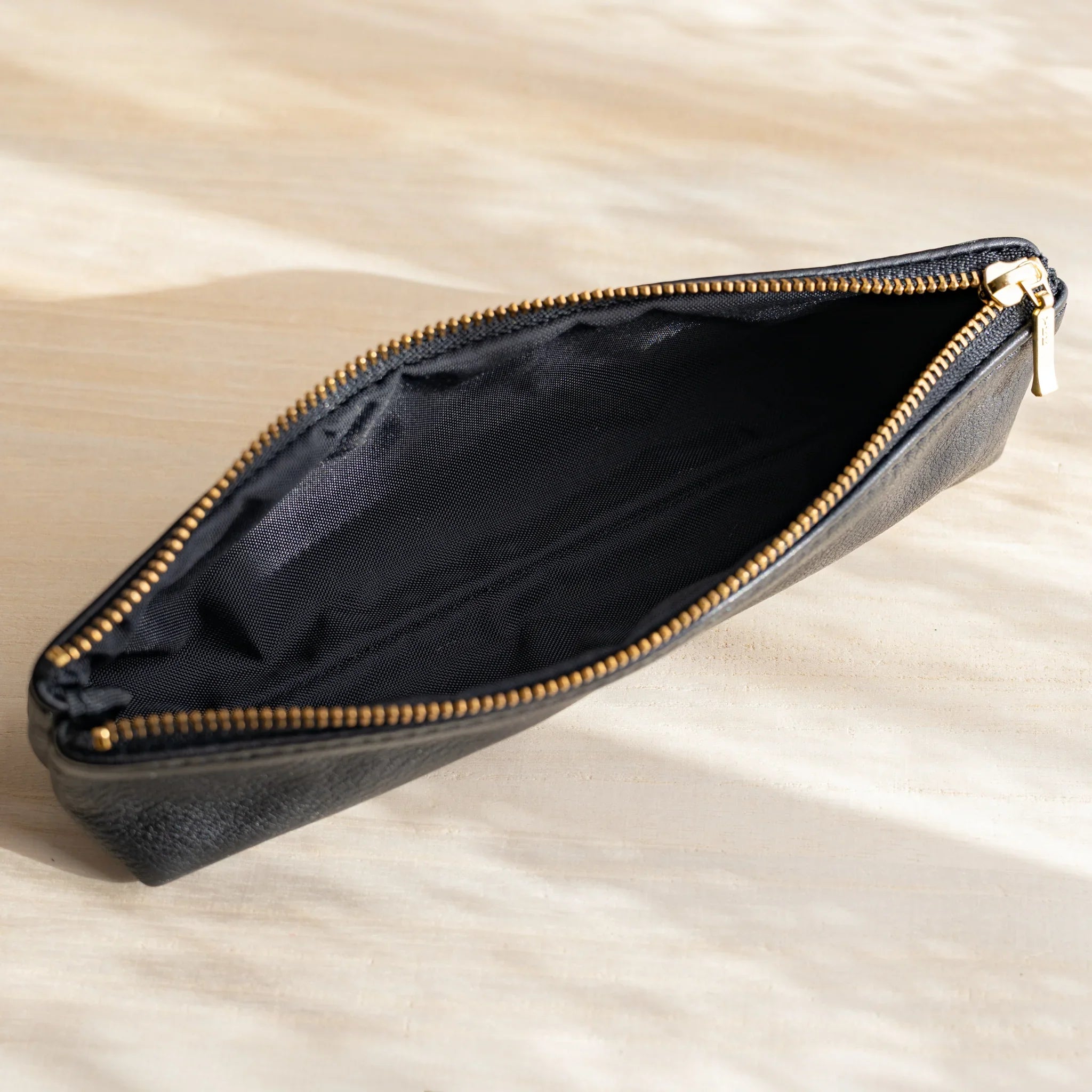 Top view of open Japanese pen case with black nylon lining and gold zipper