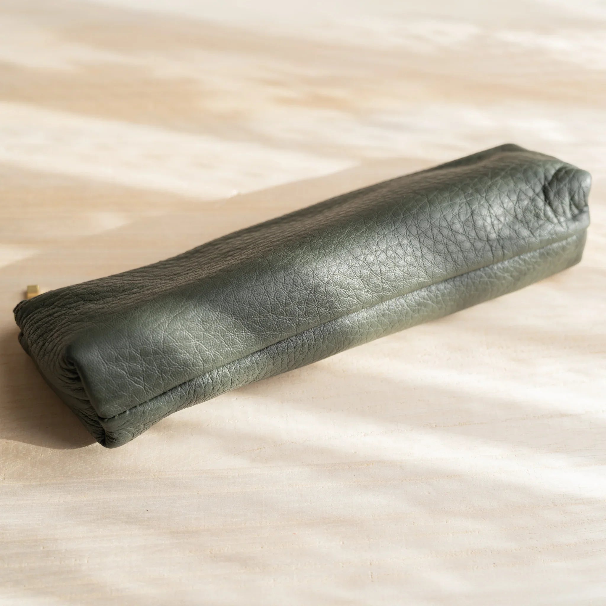 Green steerhide leather detail showing material and patina and features and features and features and features