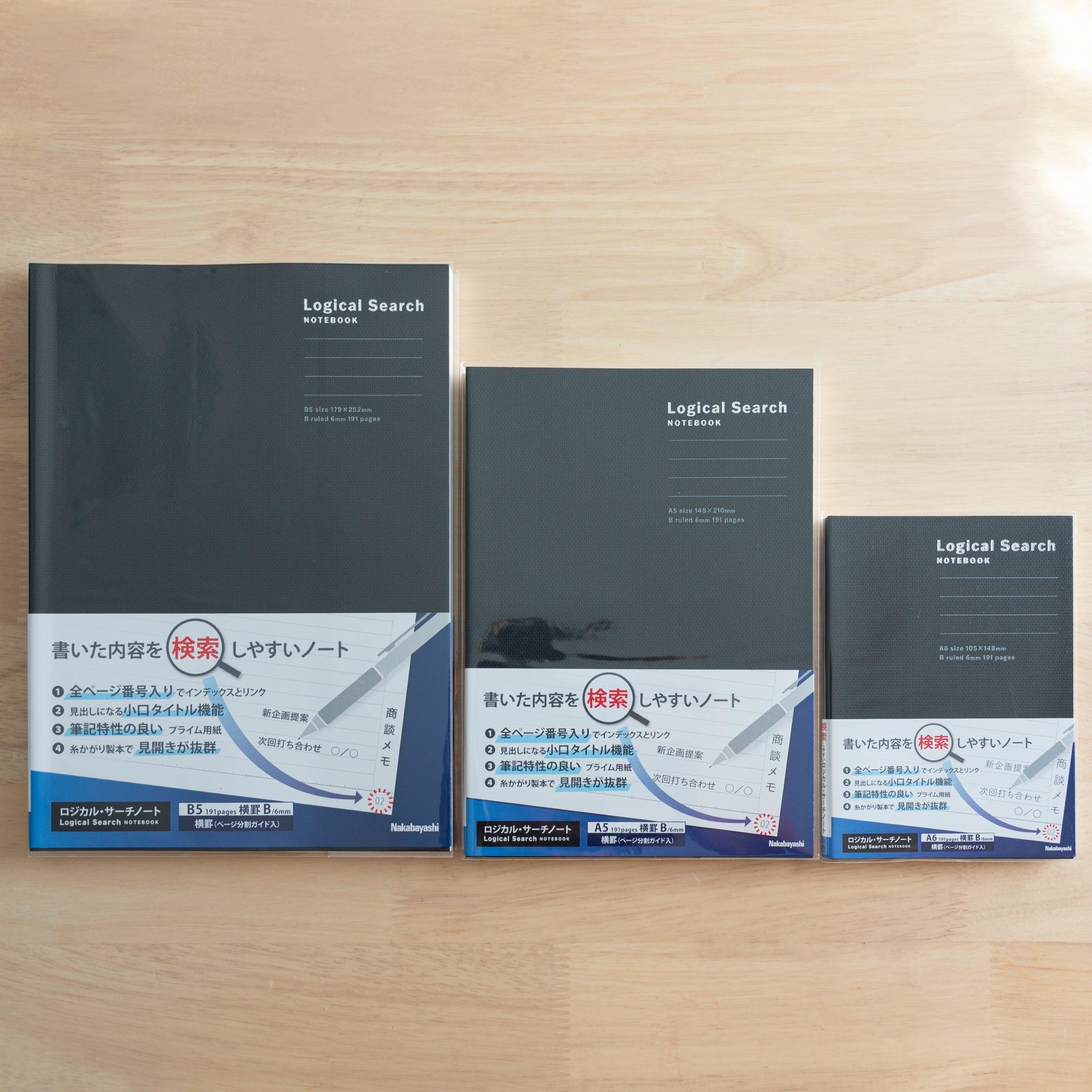 Three Japanese "Logical Search" notebooks with black covers in different sizes, sealed in plastic, placed on a wooden surface.