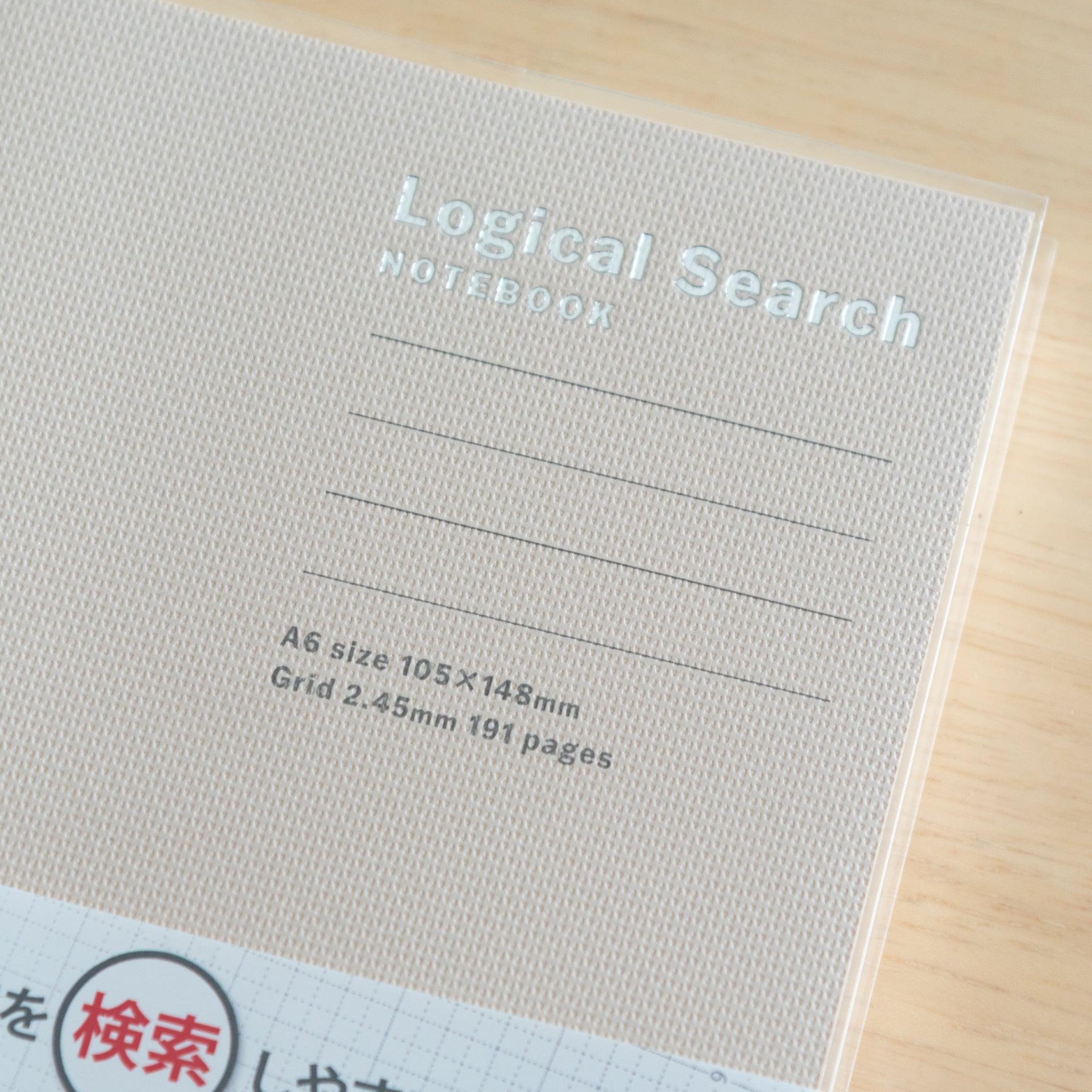 Close-up of an A6-sized Japanese "Logical Search" notebook cover, showing its beige textured surface and embossed silver title.