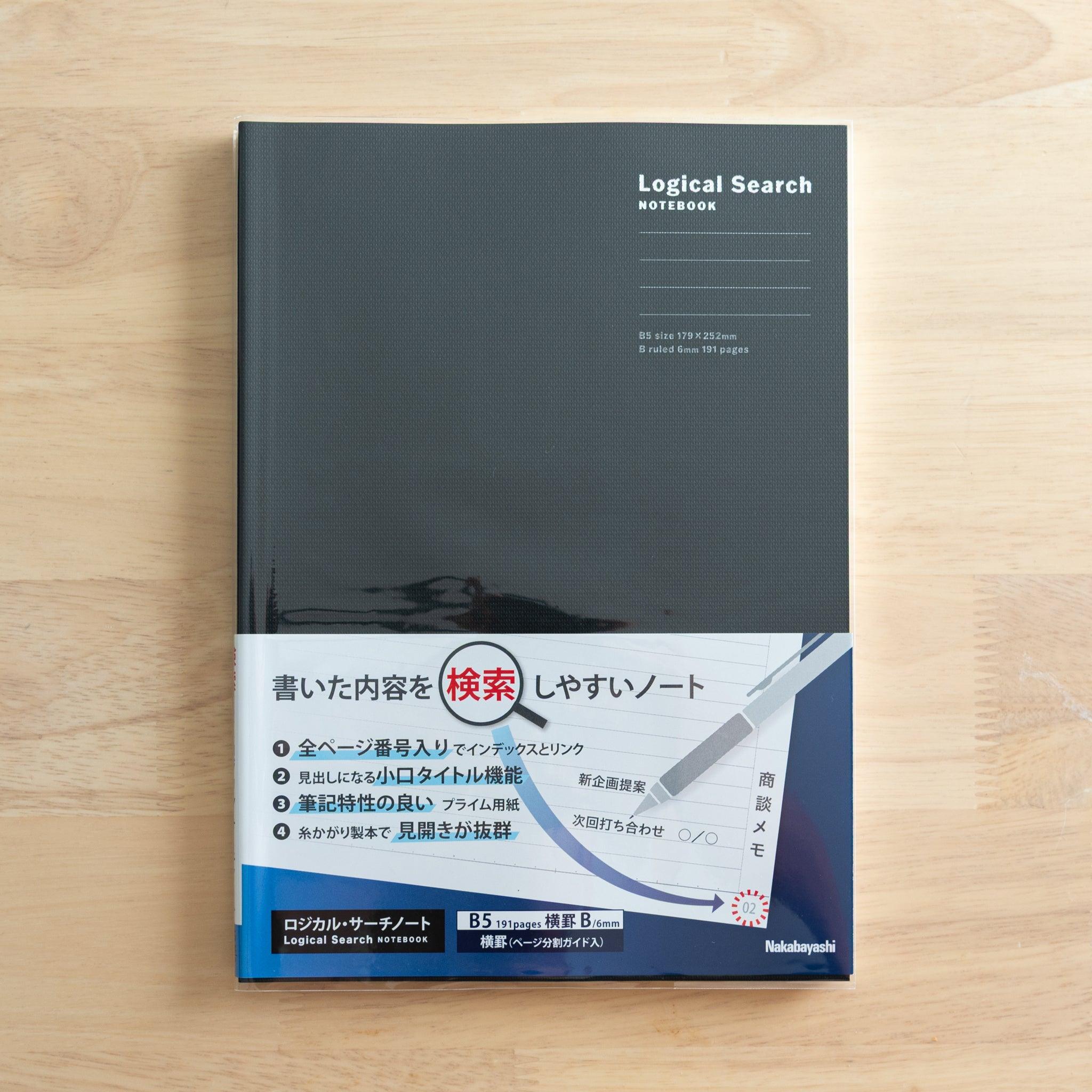 A Japanese "Logical Search" notebook with a black cover in B5 size, sealed in plastic, placed on a wooden surface.