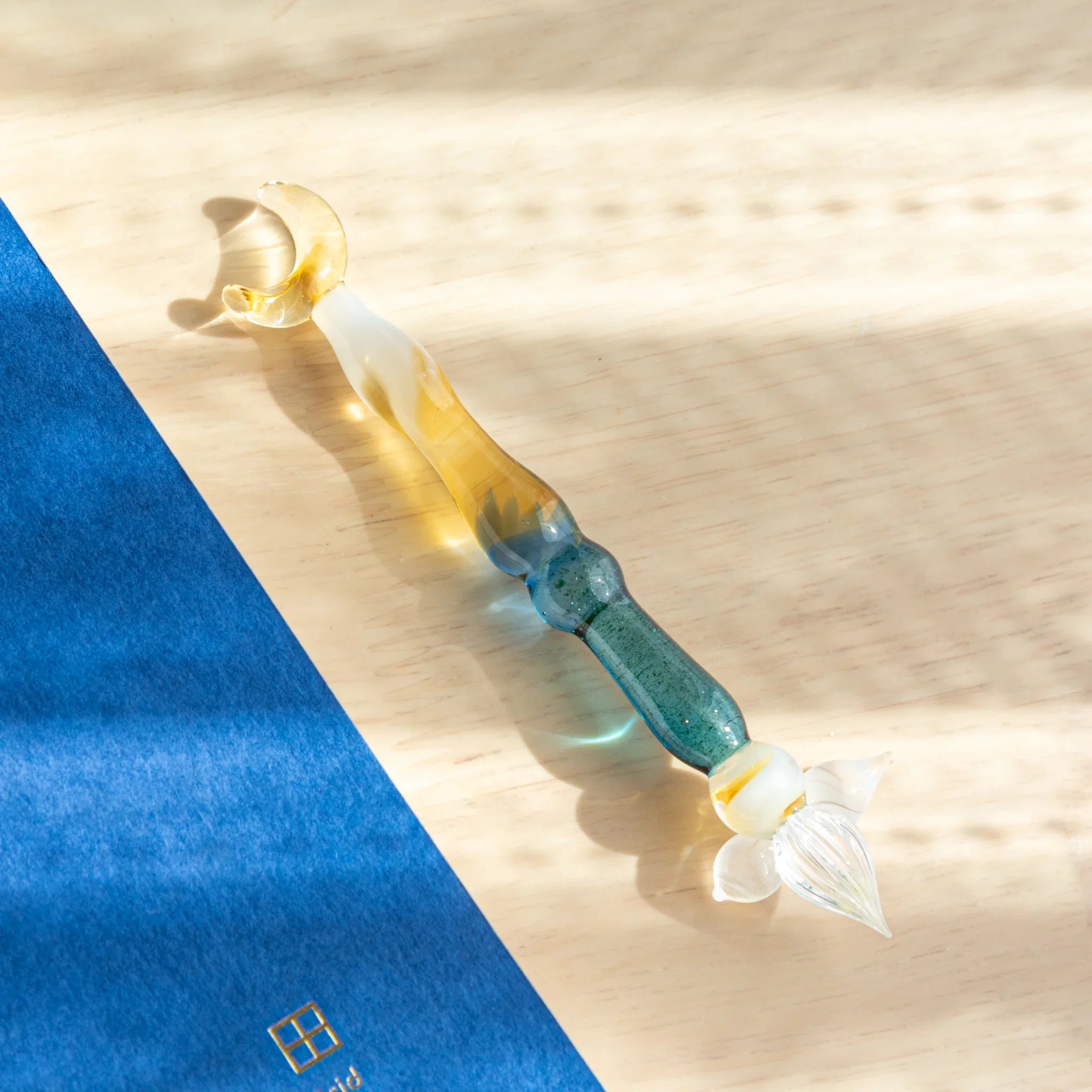 Lunar Glow glass dip pen with iridescent pale cream barrel and turquoise-wrapped center section detail display