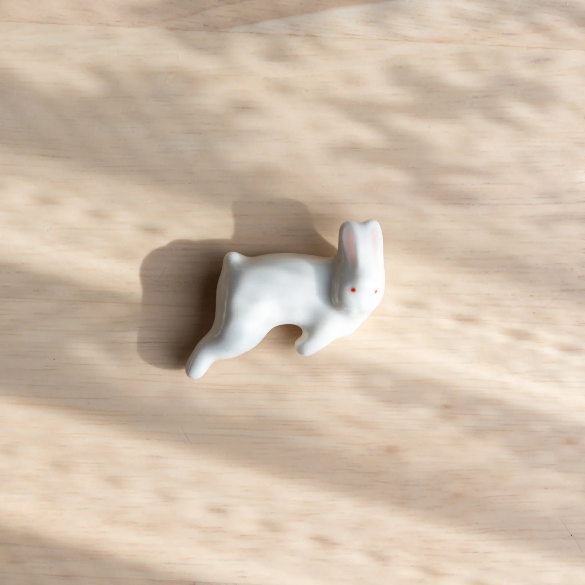 Gray lying rabbit handcrafted ceramic pen rest Japanese with detailed ears and peaceful resting posture close shot