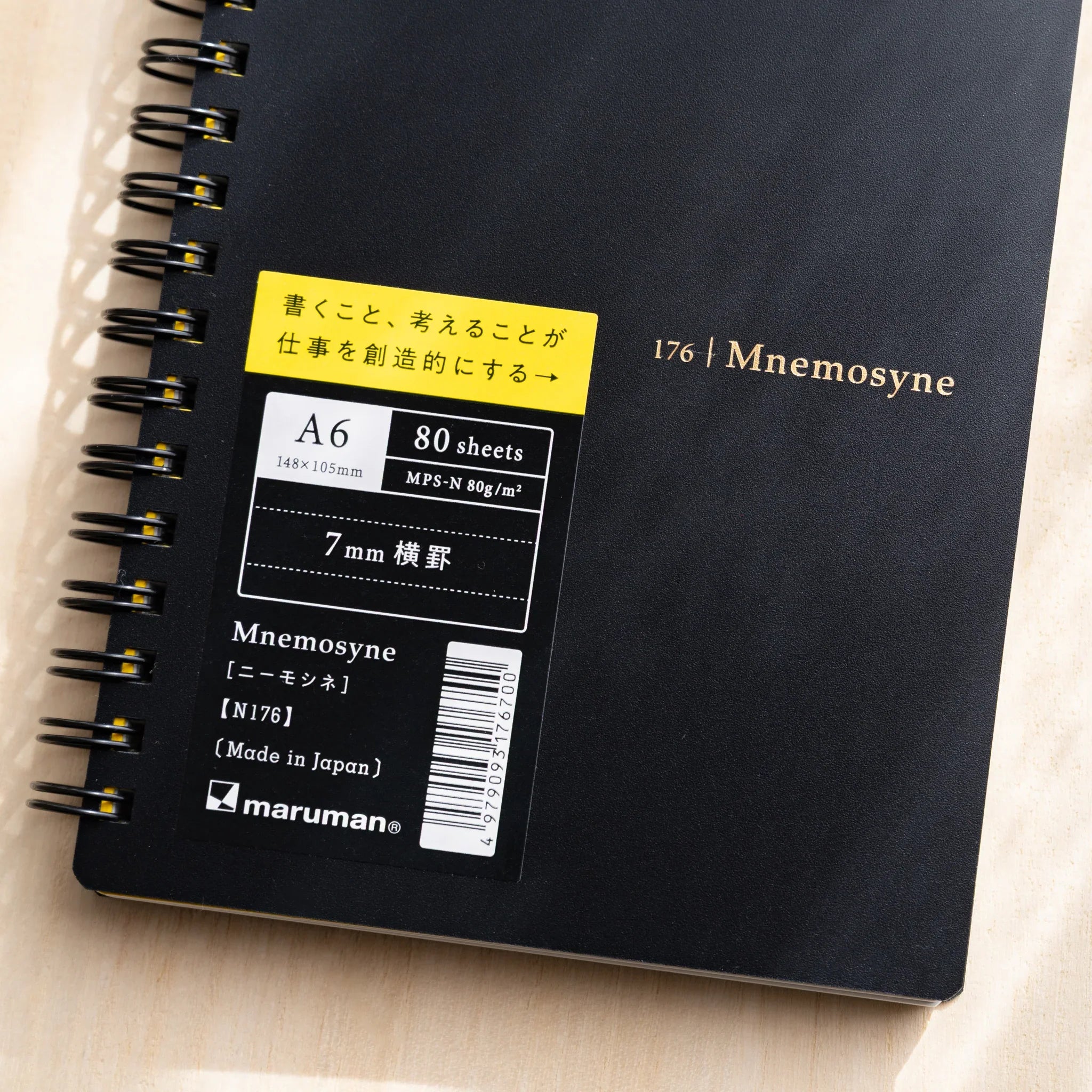 Maruman Mnemosyne notebook, flat lay of closed white lined notebook, Japanese Maruman Mnemosyne ring-bound notepad with thick
