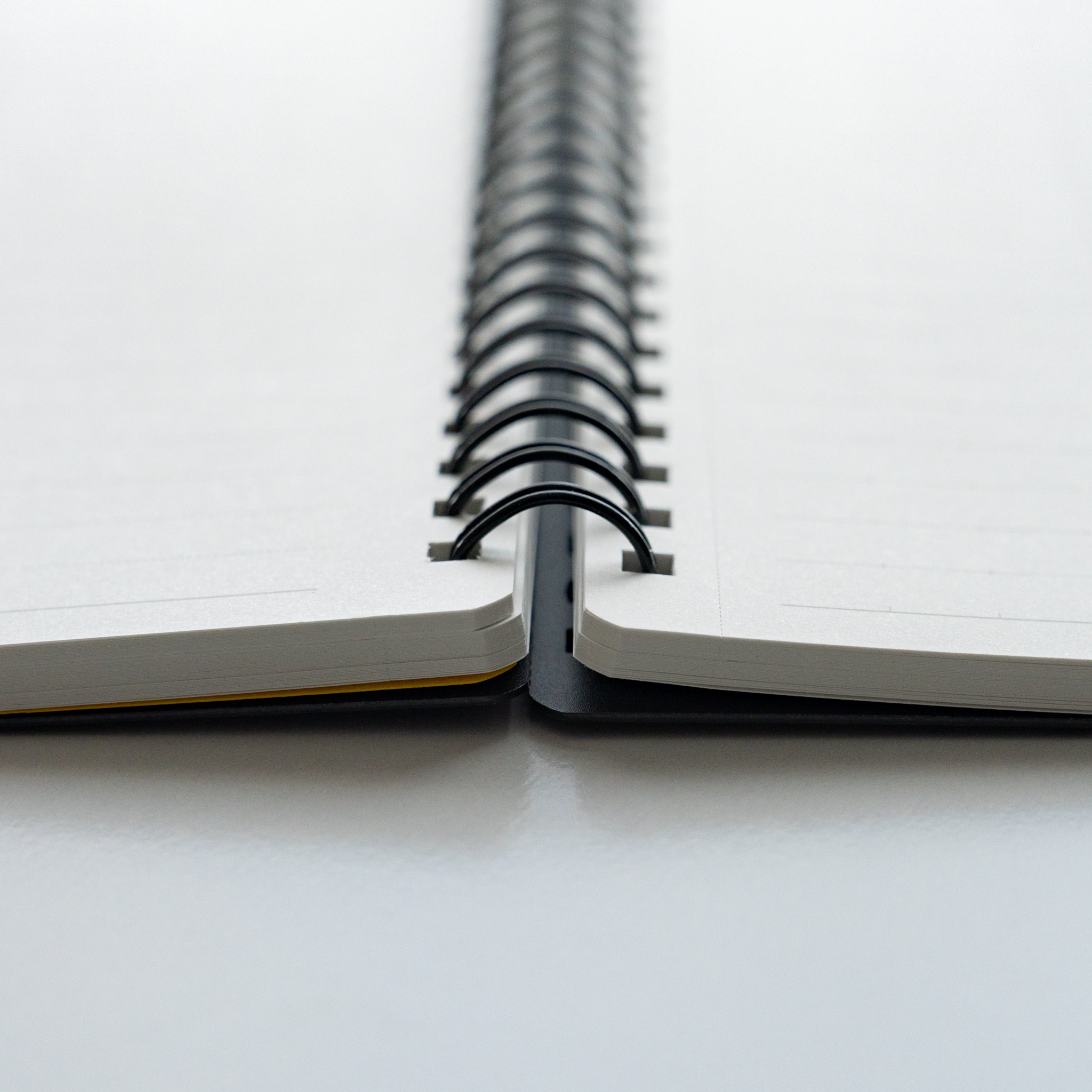 Close-up of Maruman Mnemosyne notebook with black spiral binding and lined pages lying flat for easy writing.