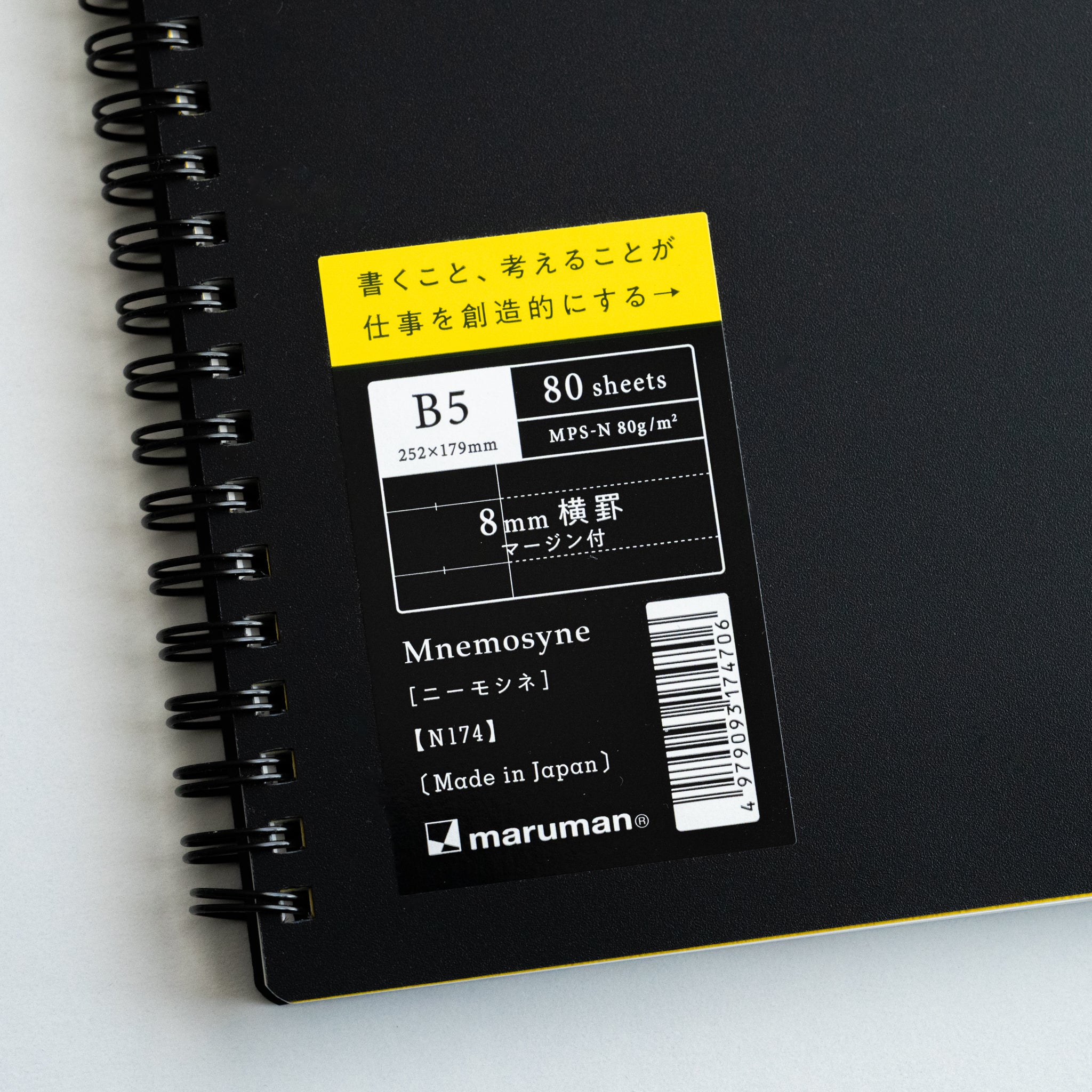 Maruman Mnemosyne B5 spiral notebook with 80 sheets of 8 mm lined paper and a yellow label on black cover.