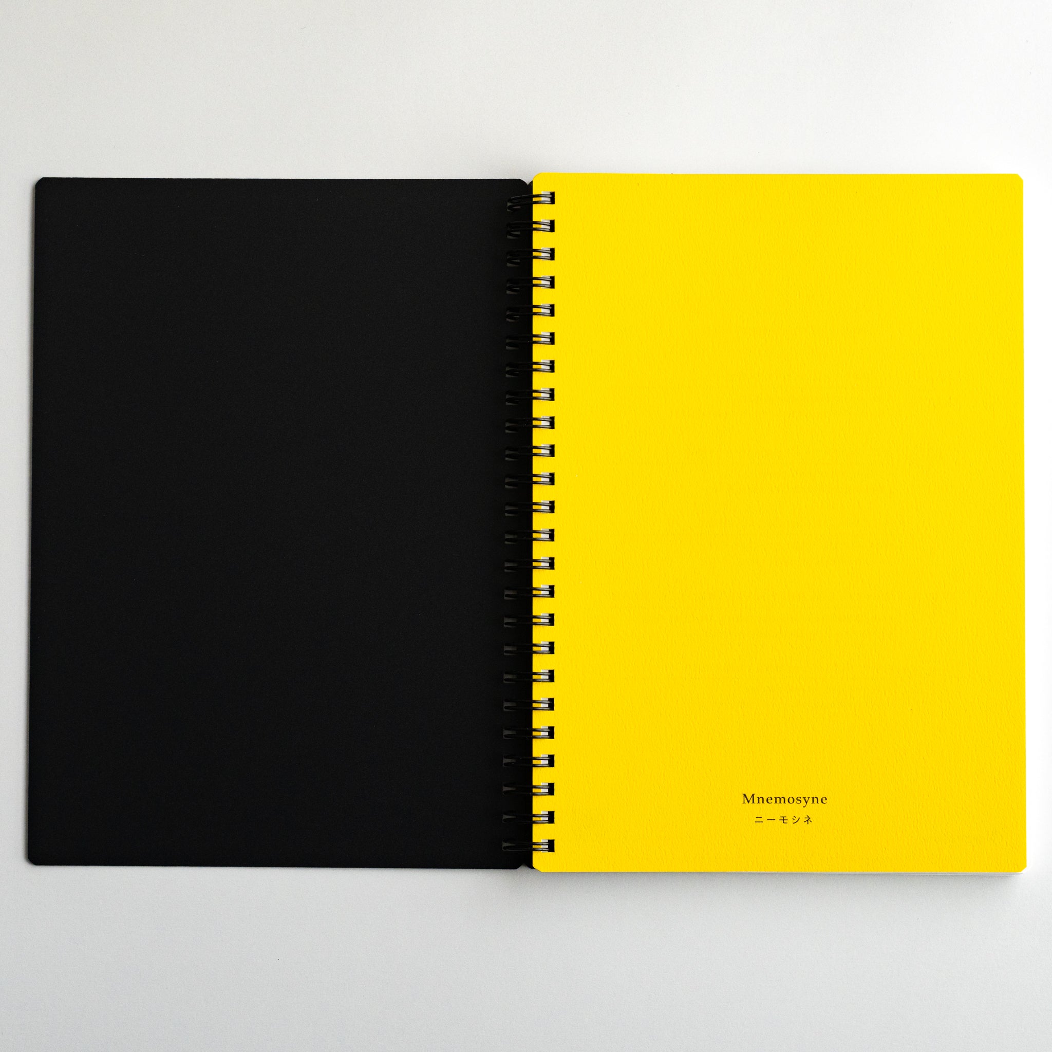 Open Maruman Mnemosyne notebook with black cover and yellow page, spiral-bound Japanese stationery for ideas