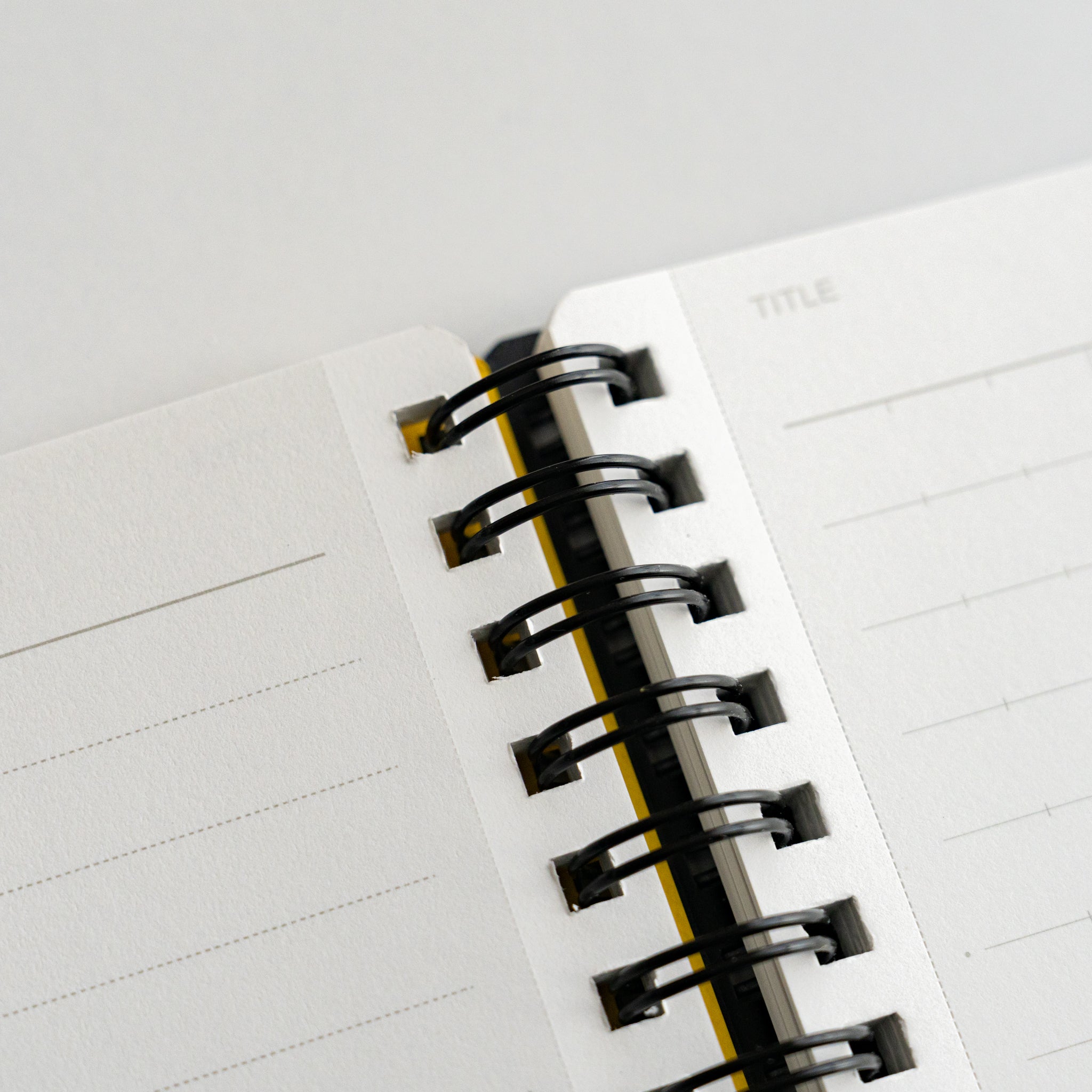 Close-up view of Mnemosyne notebook spiral binding and lined pages, showcasing durable black rings and clean ruled paper