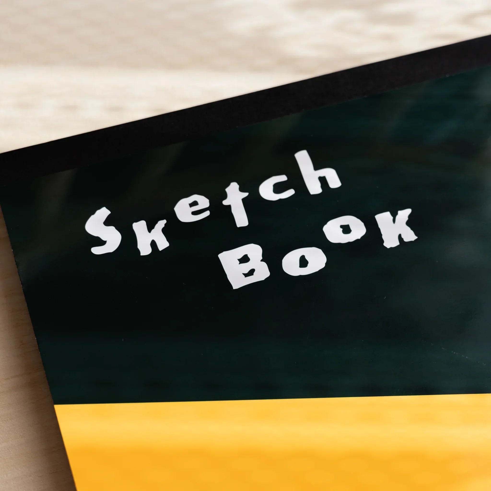 Cover of a Maruman Japanese sketchbook featuring black and orange bands with bold white Sketch Book lettering for arts and crafts.