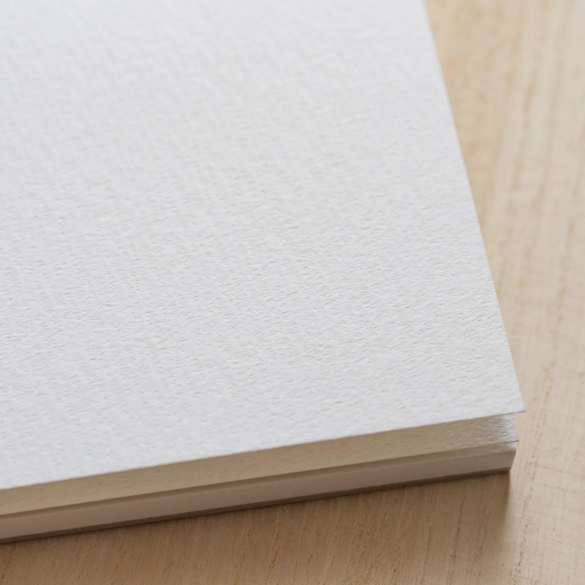 Maruman Zuan sketch pad, angled composition highlighting paper surface, Japanese stationery item with quality construction