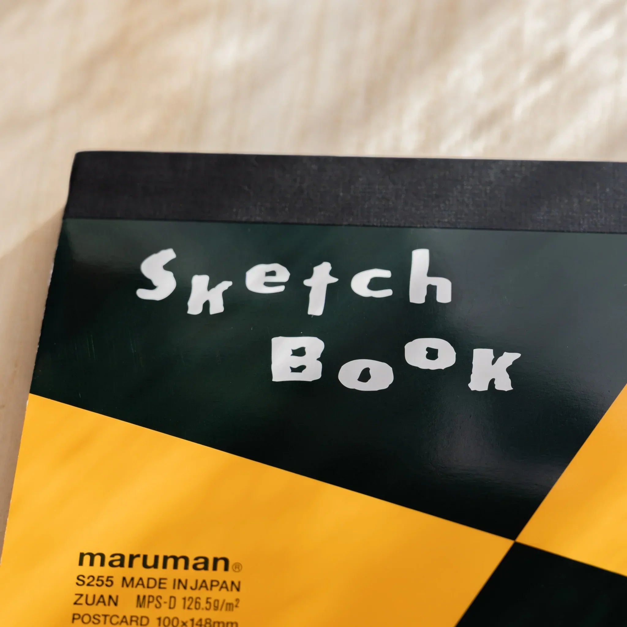 Maruman Japanese sketchbook cover with orange and black geometric design, white Sketch Book lettering, and top binding.
