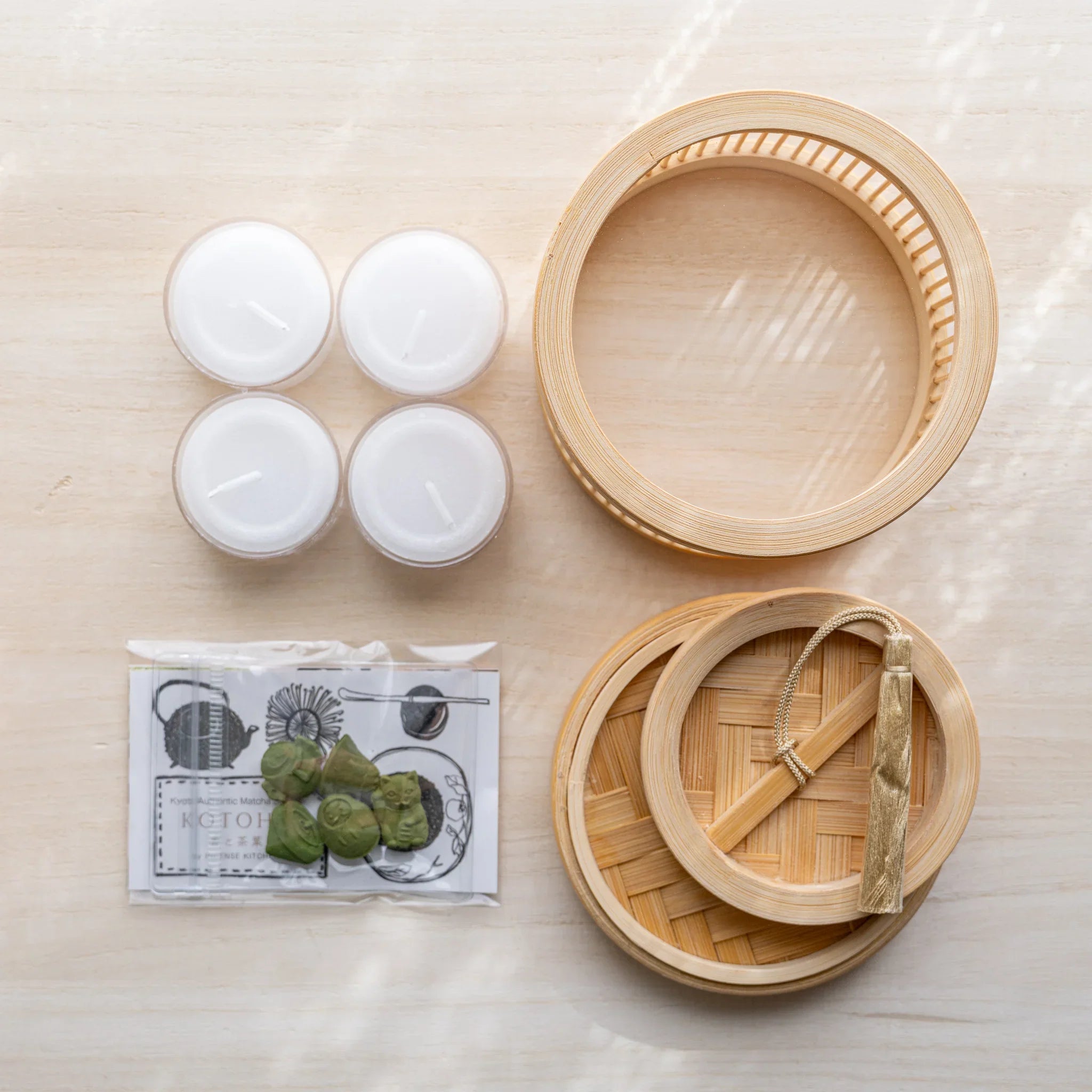 Suruga bamboo matcha incense warmer kit components: bamboo warmer, woven lid with silk tassel, four tealights, incense pack