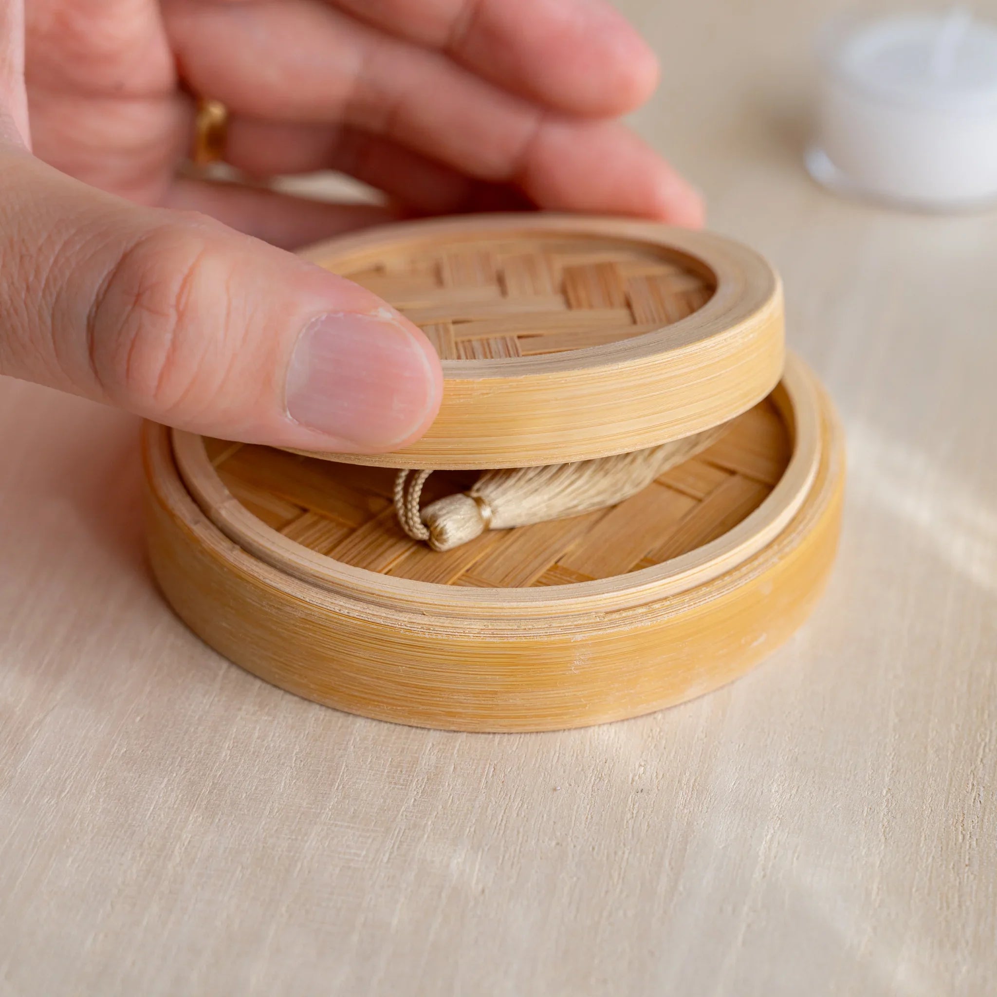 Suruga bamboo matcha incense tea warmer with three pressed matcha pieces on top and a lit tealight glowing inside