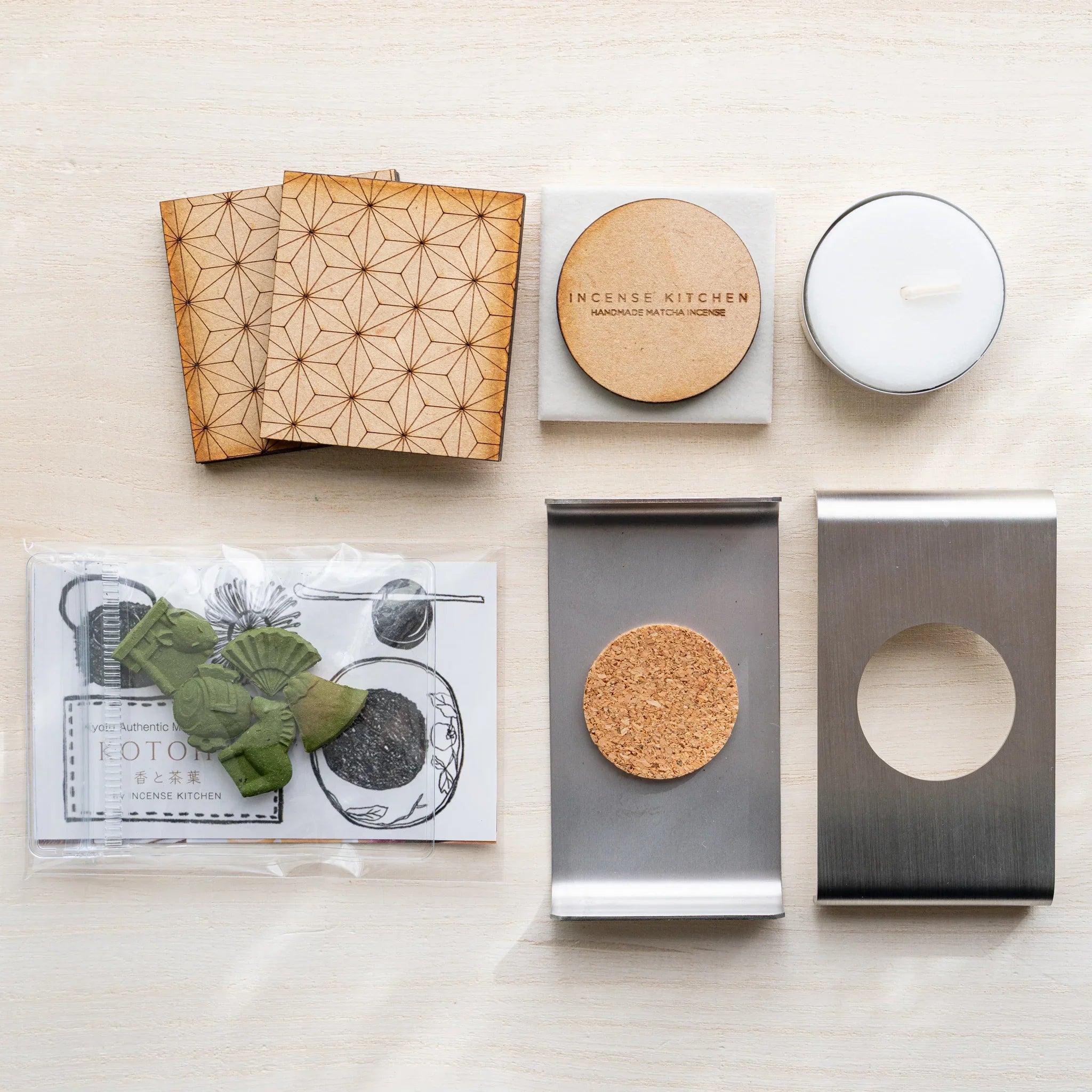 Foldable matcha incense tea warmer components: asanoha wood panels, ceramic plate, cork pad, steel frame, incense, candle