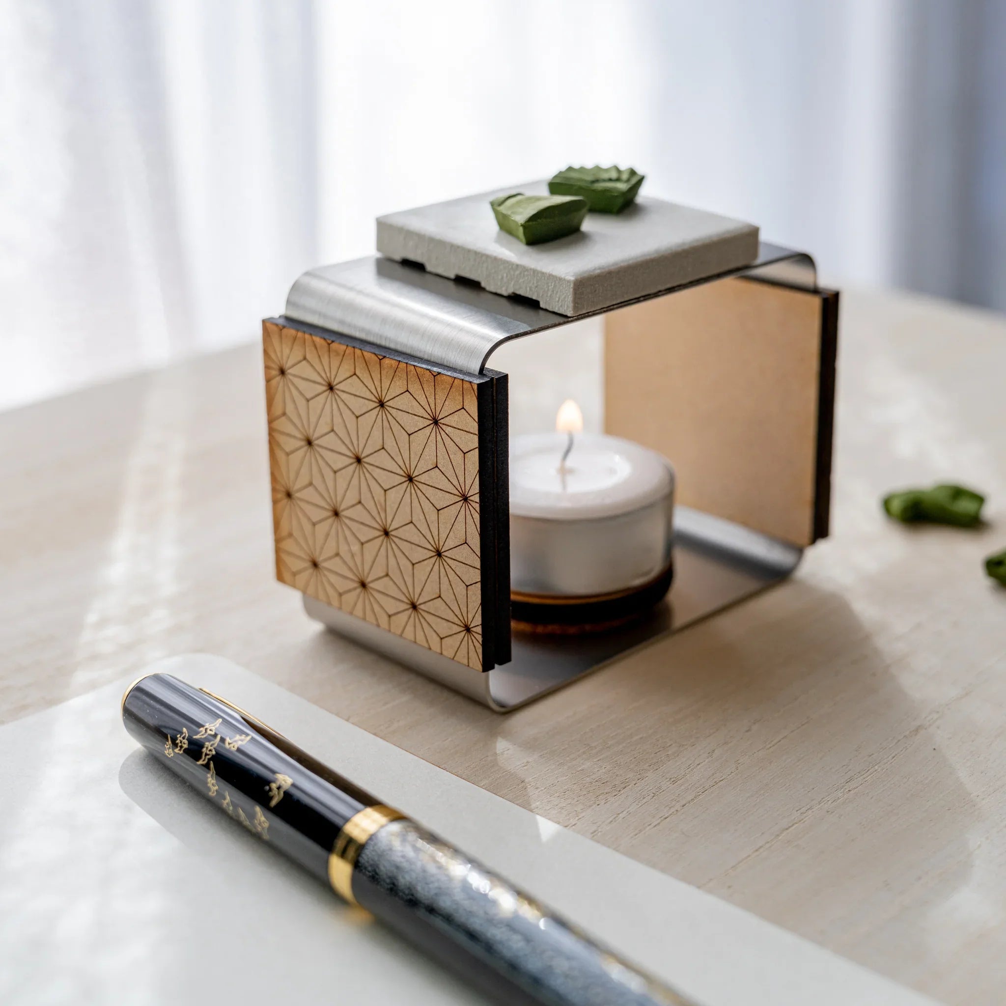 Matcha incense tea warmer with asanoha laser-cut wood side panel, lit tealight inside, and pressed matcha pieces on top