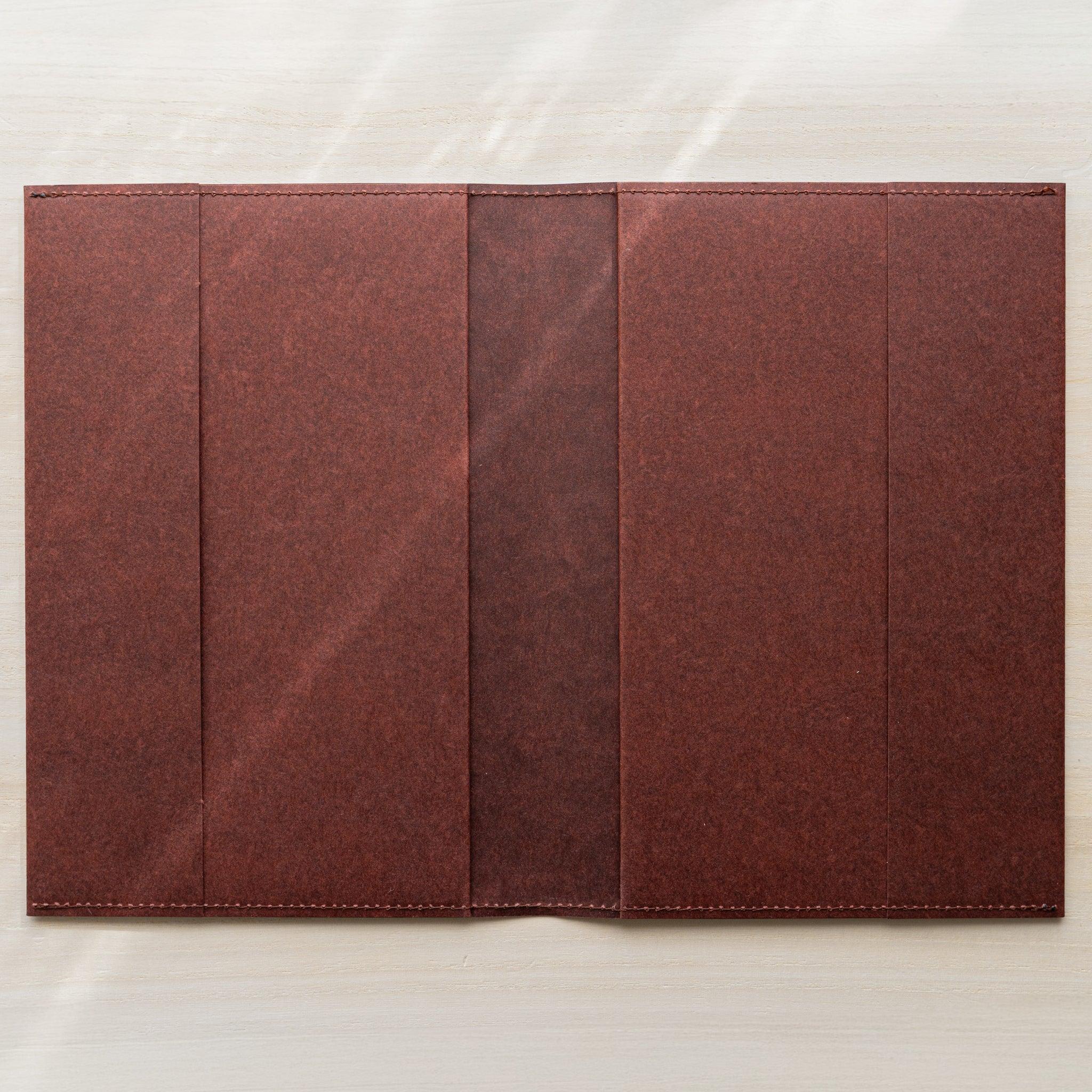 Midori MD Notebook Hard Cover opened flat from above, dark red hard paper with four panels and stitched edges