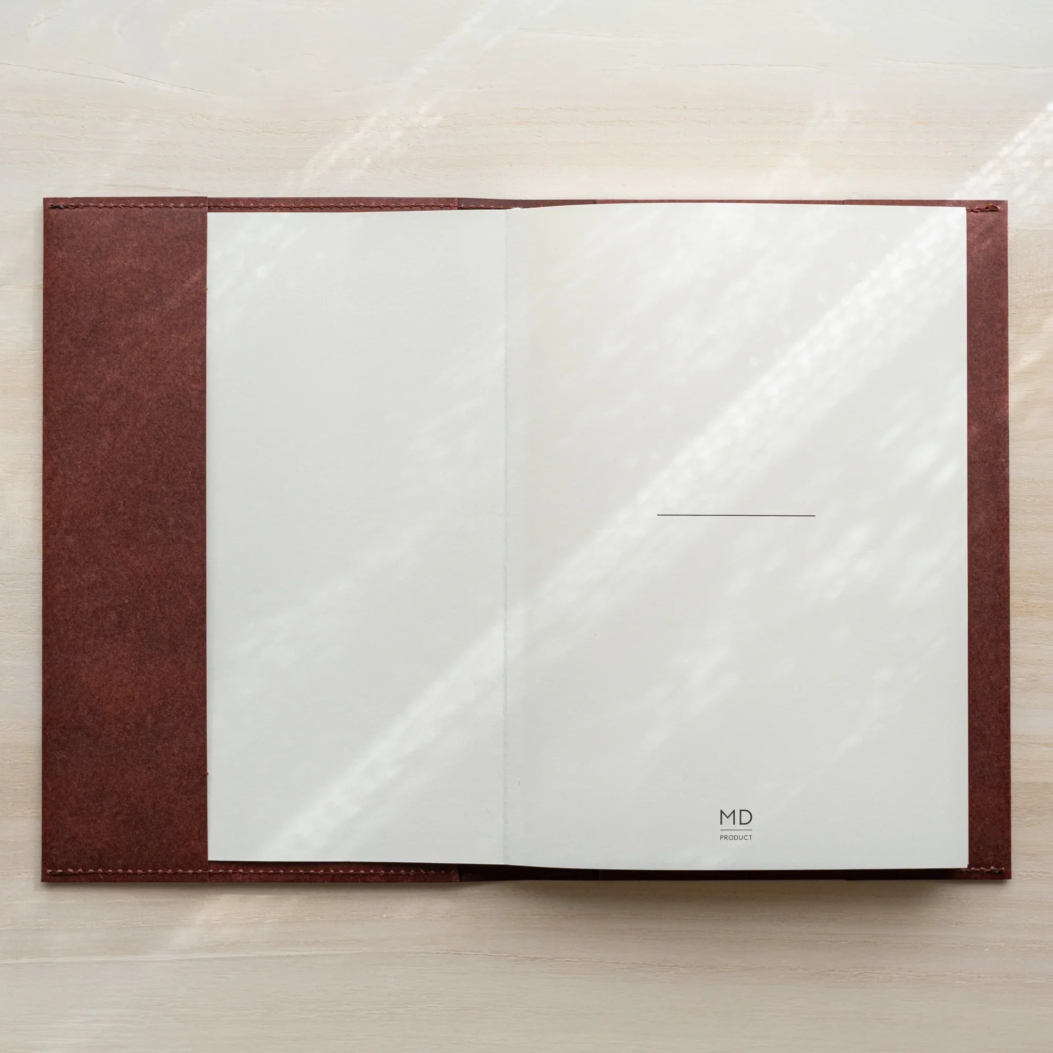Midori MD Notebook Hard Cover opened flat, white inner panel with MD Project logo, dark red flaps on sides