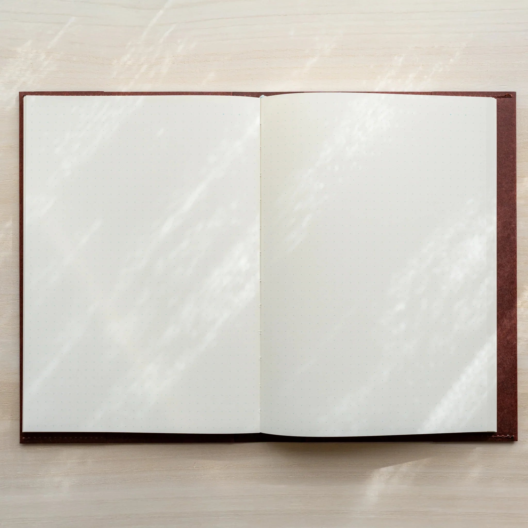 Midori MD Notebook Hard Cover with notebook inserted, open to blank white page spread, dark red cover frame visible on sides