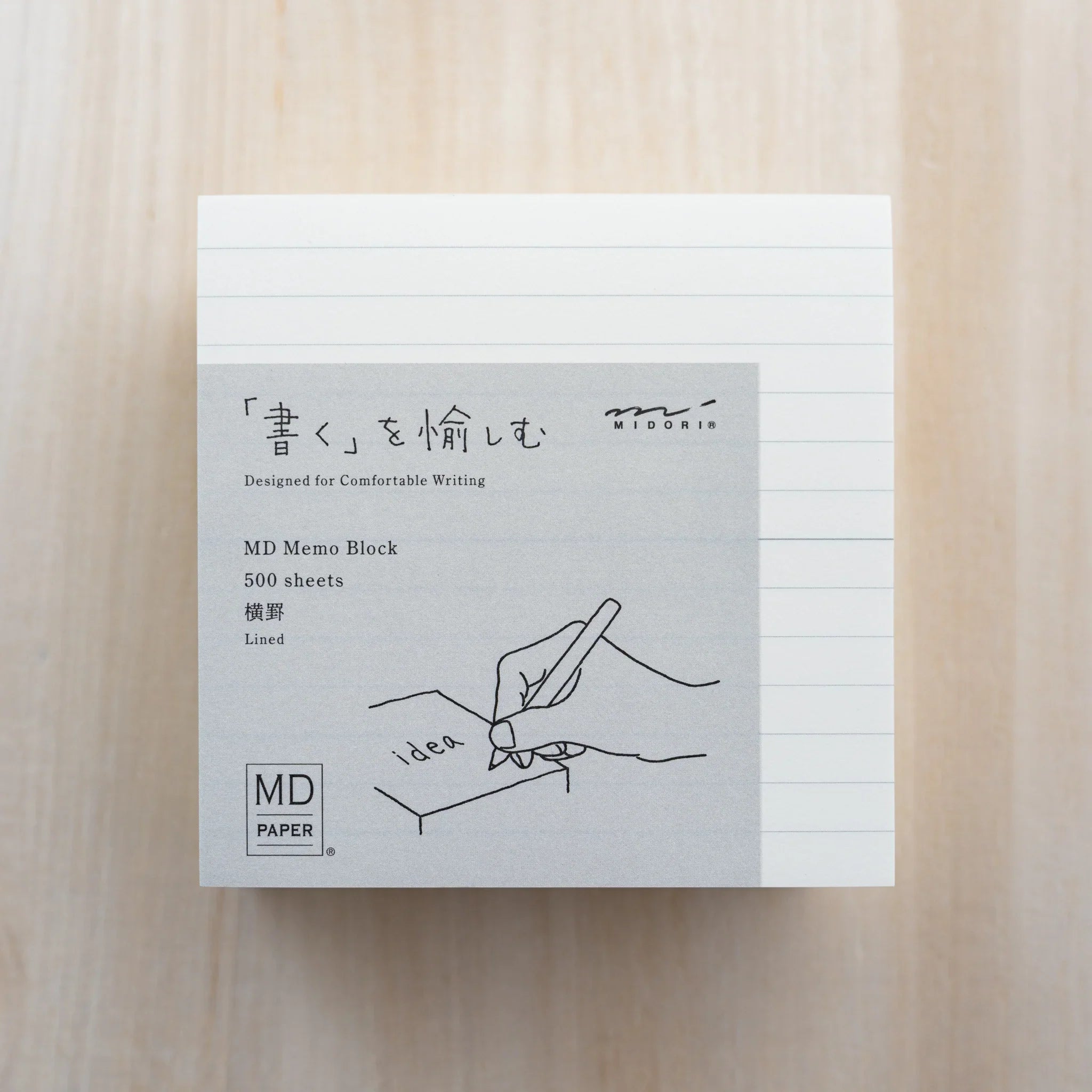 MD Memo Block lined type, gray wrap reading MD Memo Block 500 sheets Lined with Midori logo and hand illustration