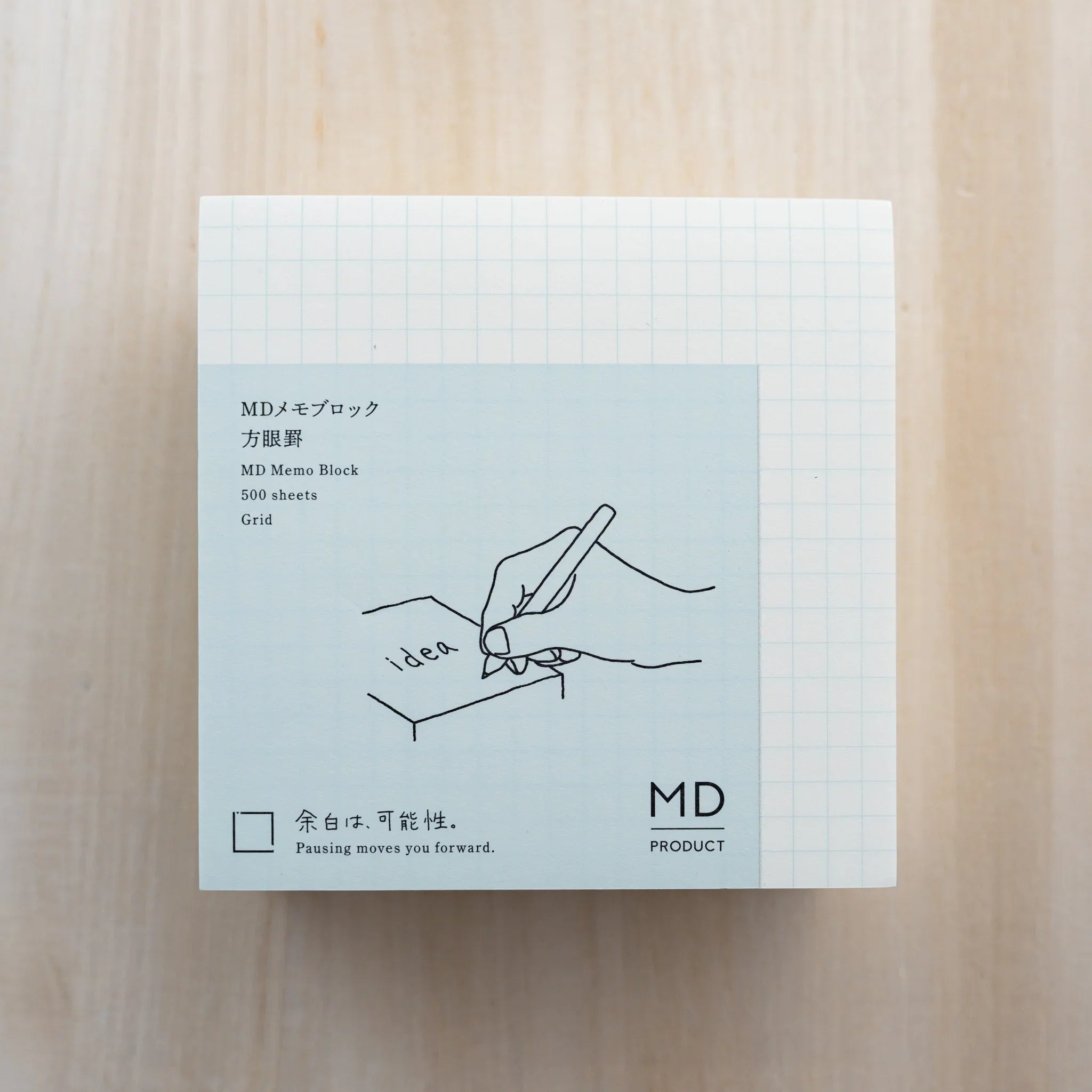 MD Memo Block grid type, light blue wrap reading MD Memo Block 500 sheets Grid with hand illustration over a grid sheet