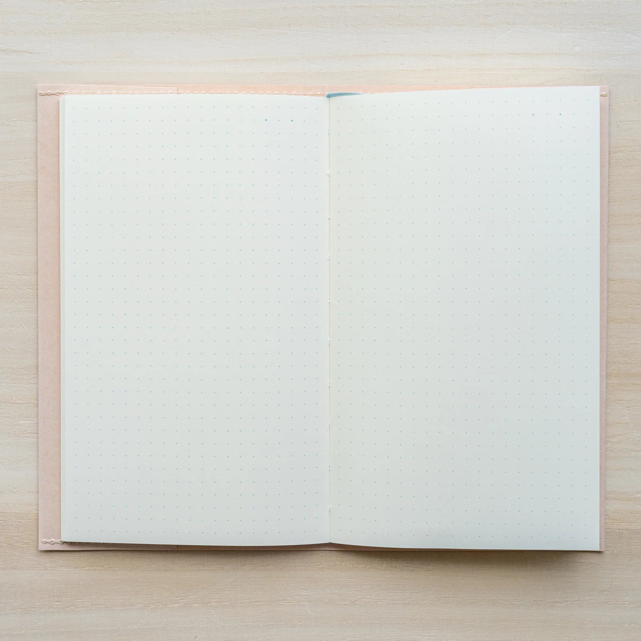 MD Paper Notebook Cover with notebook inside, open flat top-down view showing blank white pages and blue ribbon bookmark