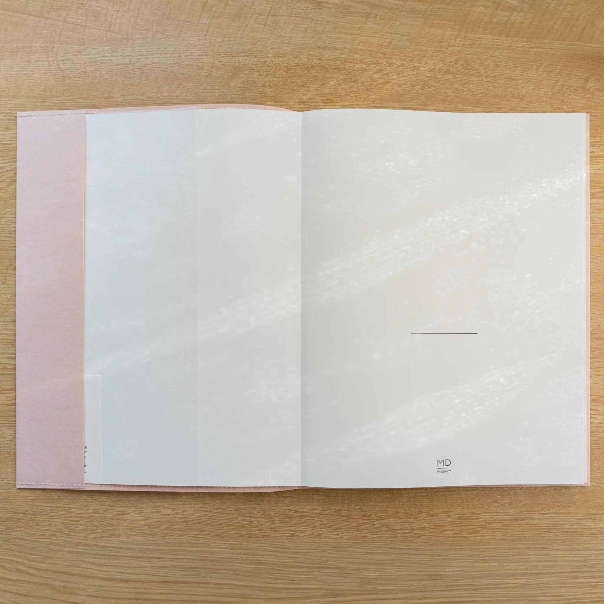 Notebook inside a pale pink MD Notebook Paper Cover, open showing a white page and cover flap