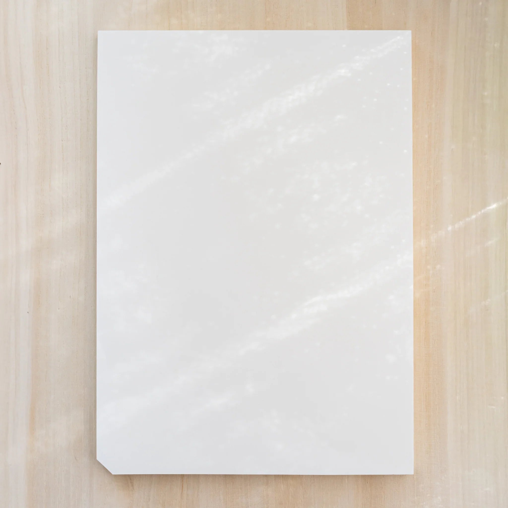 Midori MD Paper Pad Cotton A4, plain blank white top sheet with one cut corner, no belly band, on light wood