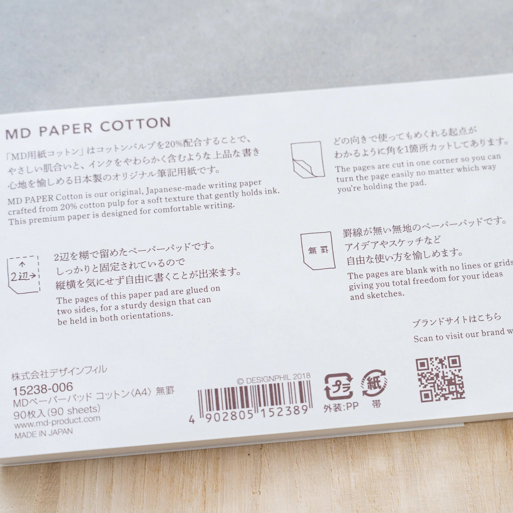 Close-up of Midori MD Paper Pad Cotton A4 belly band text on 20% cotton paper, 90 sheets, blank, cut corner