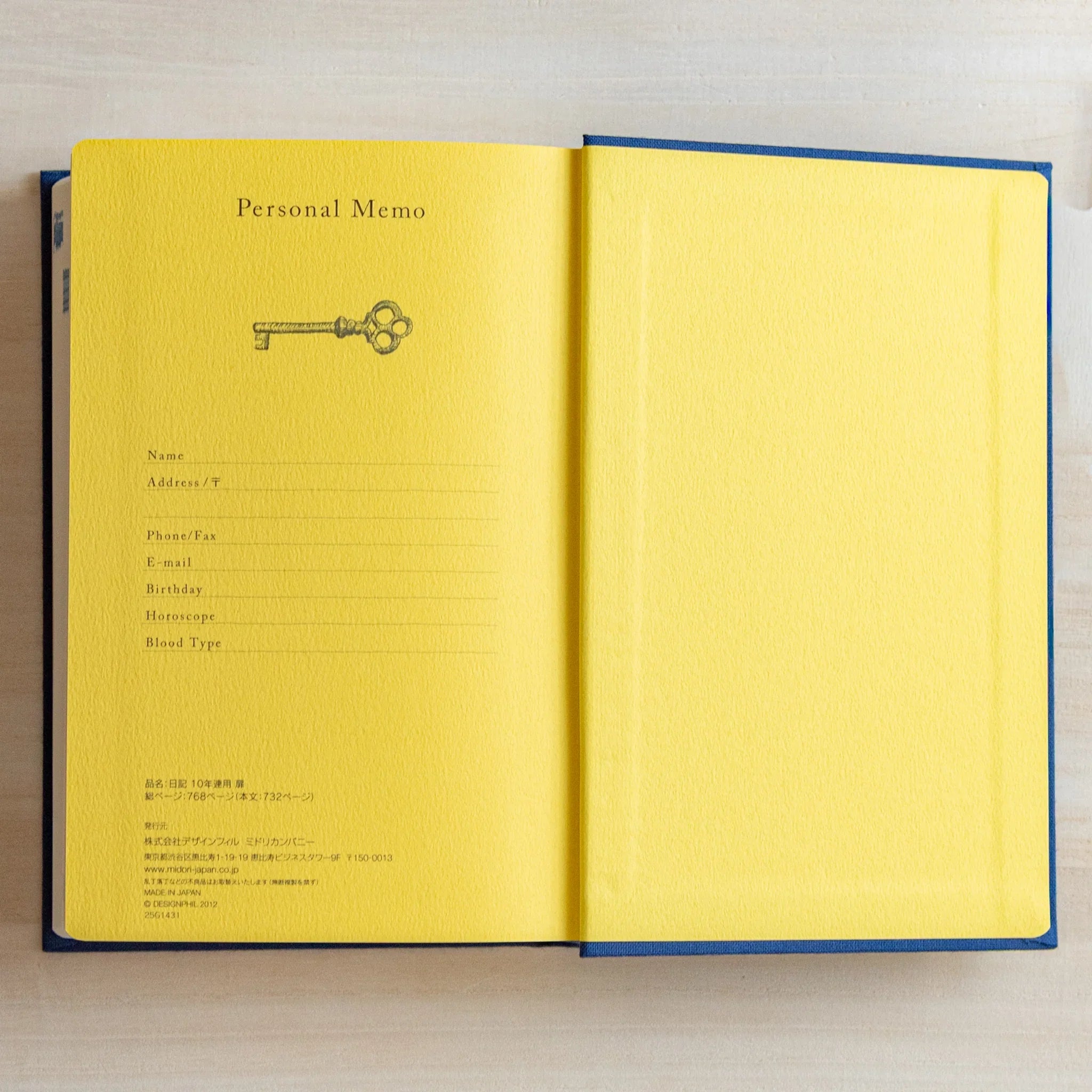 Open Midori Japanese journal 10-year diary gate design with yellow personal memo page and key illustration.