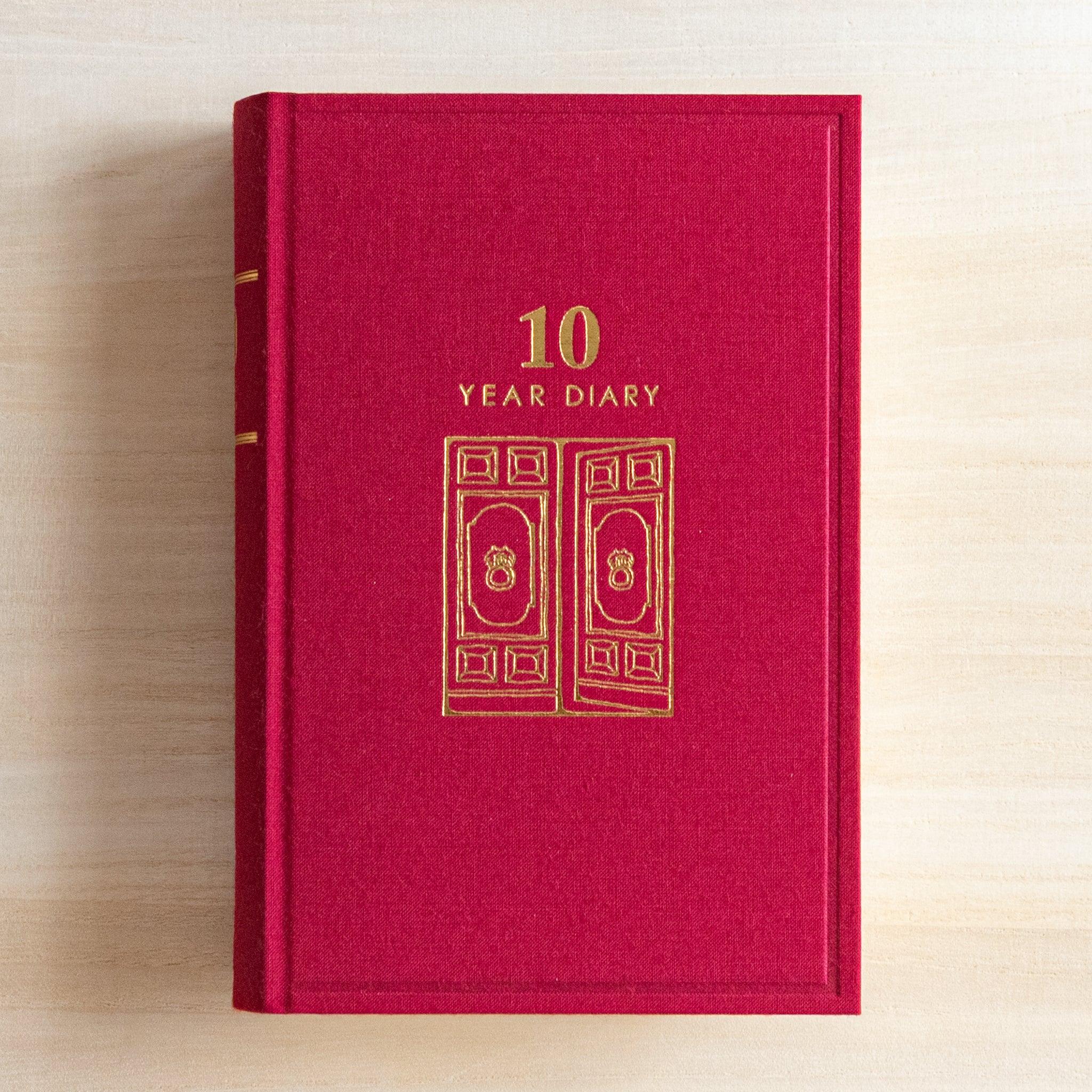 Front cover of Midori Japanese journal 10-year diary gate design in red with golden door illustration.