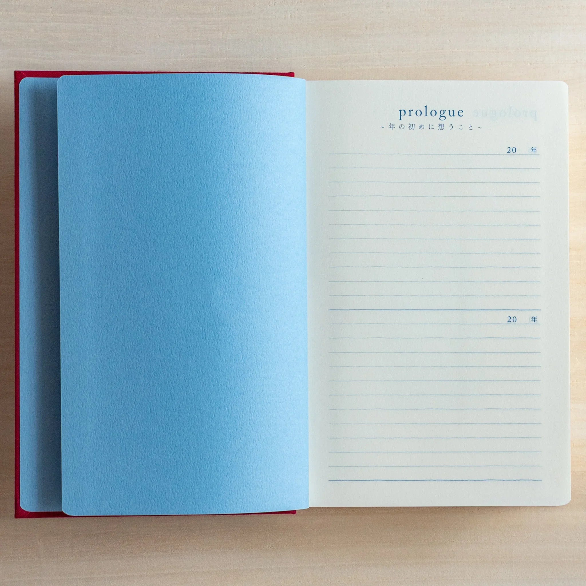 Open Midori Japanese journal 10-year diary gate design showing blank blue page opposite prologue lined page.