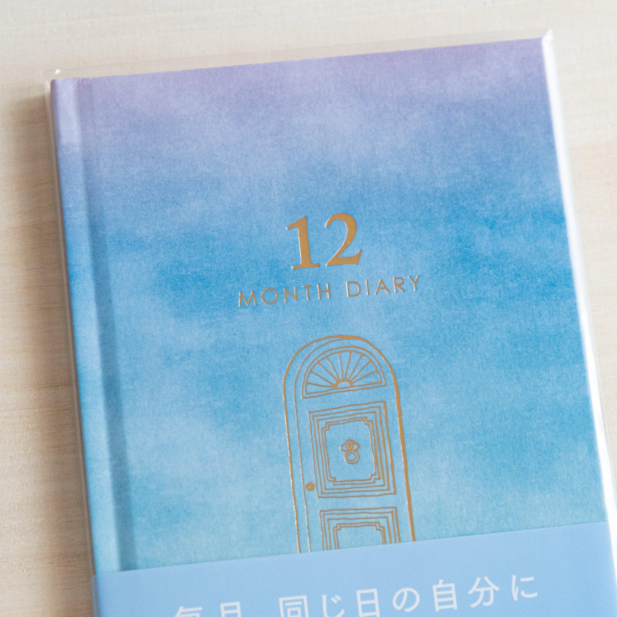 Interior spread of diary showing monthly calendar with decorative gold border design detail visible clearly