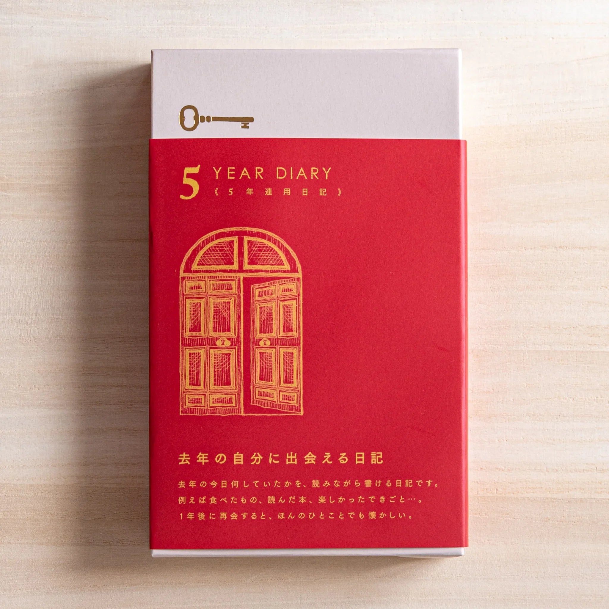 Red Midori 5 Year Journal Gate Design Japanese Journal partially pulled from its slipcase with gold gate foil.