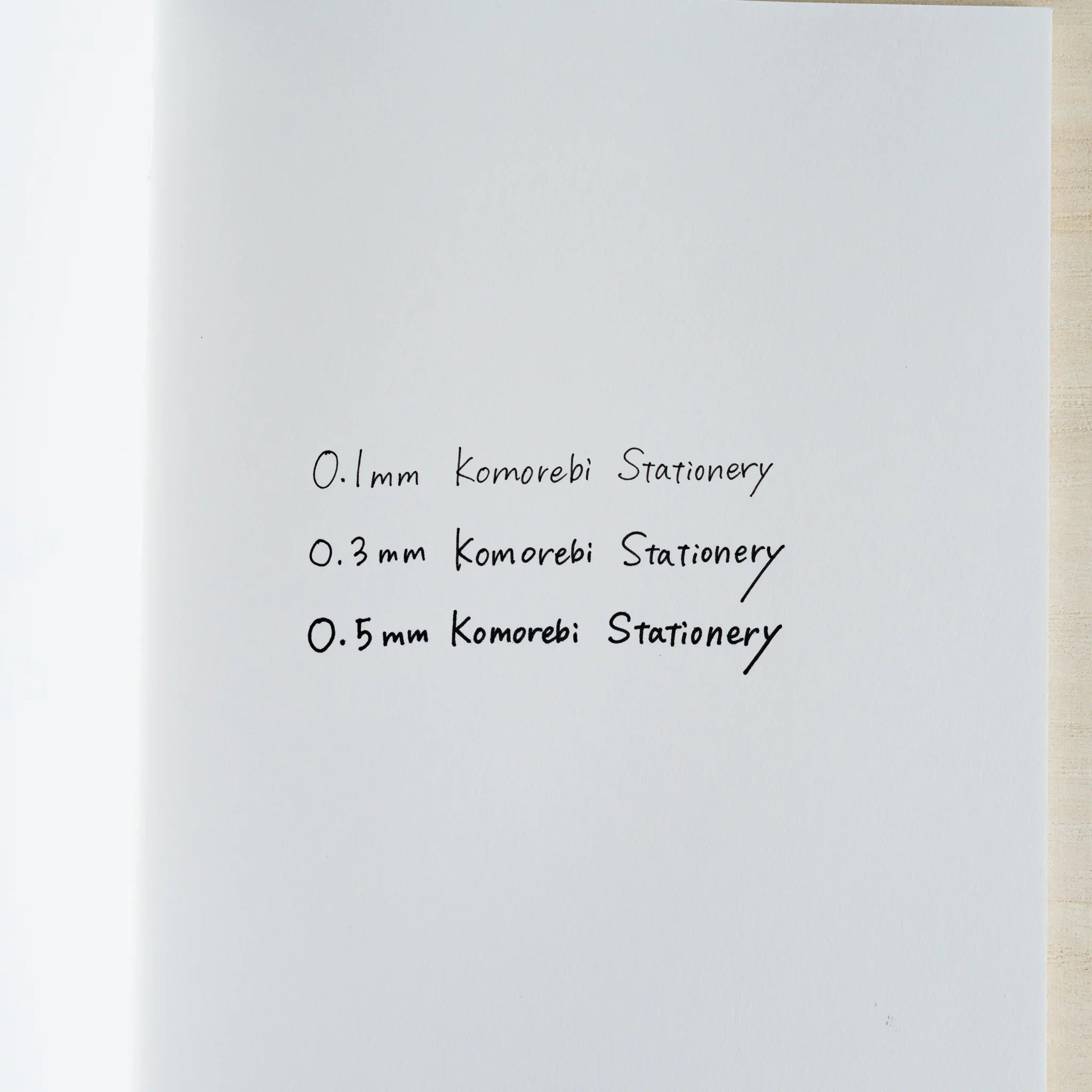 Handwritten ink sample on white paper showing 0.1, 0.3, and 0.5 mm line widths, each written as Komorebi Stationery