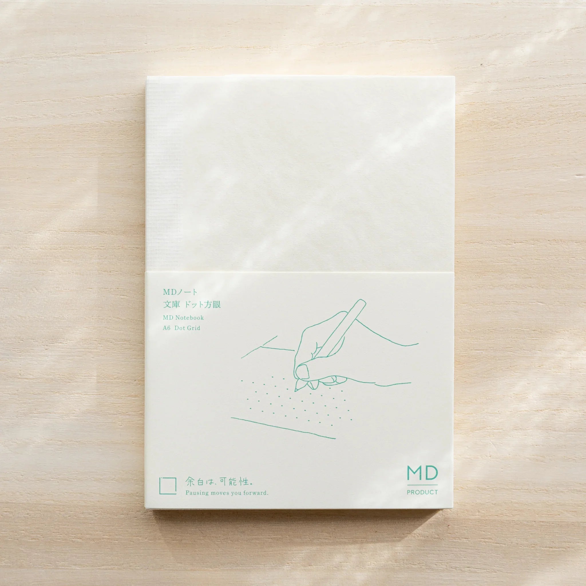 Midori MD Notebook A6 Dot Grid with glassine cover, teal hand-writing illustration and MD Product logo on front
