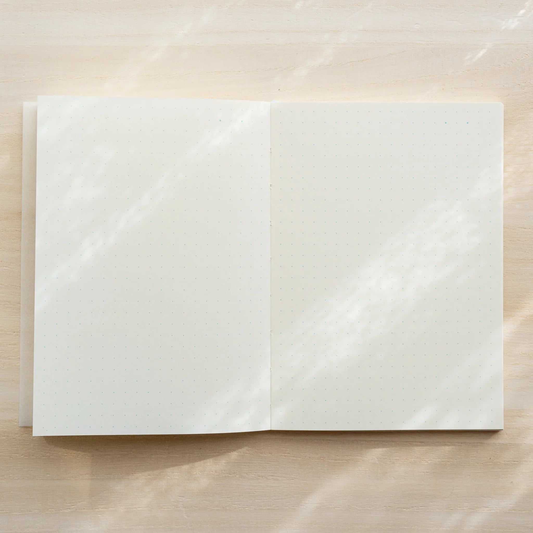 Midori MD Notebook A6 opened flat from above showing blank ivory page spread, center spine visible