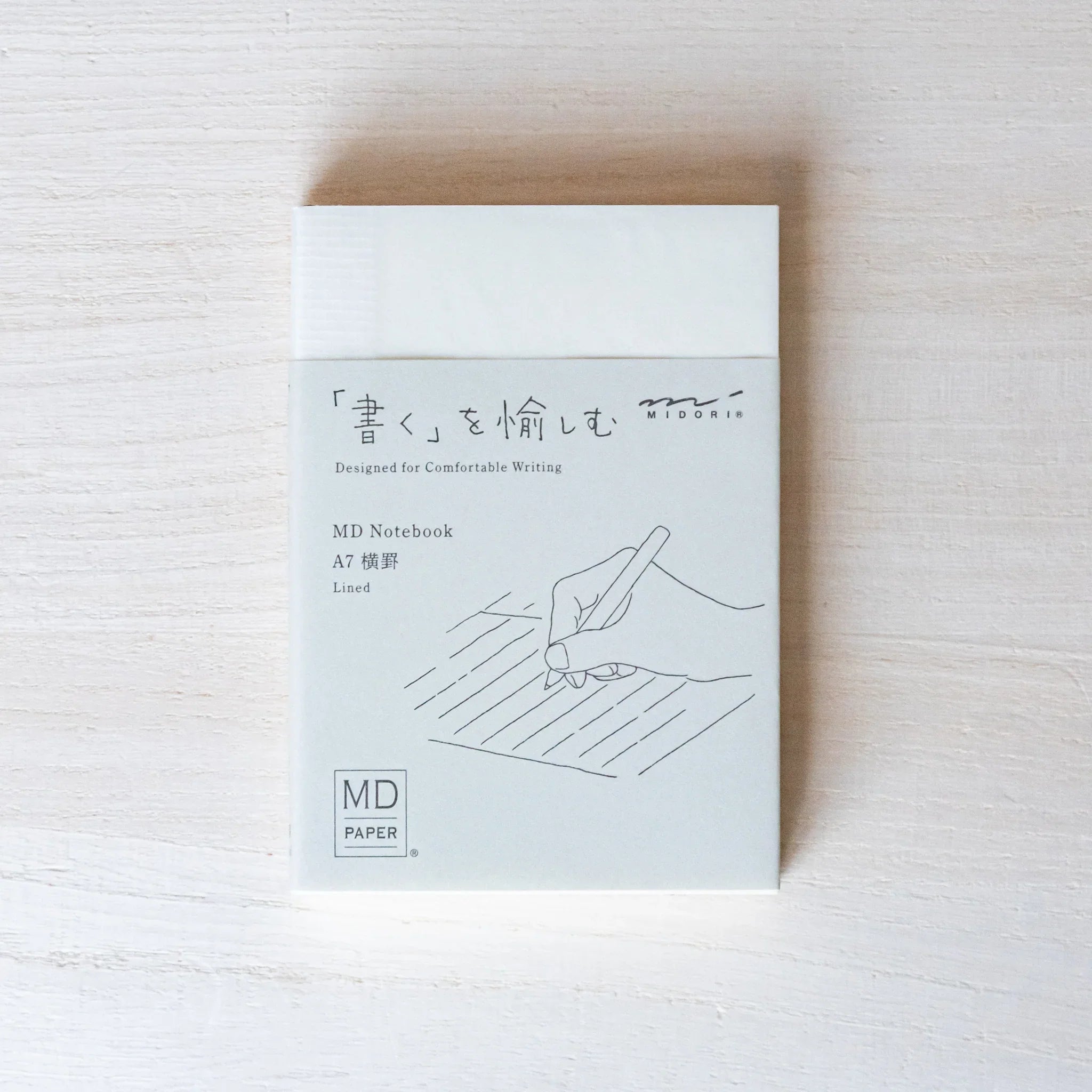 Midori MD A7 notebook, angled view highlighting A7 size, Japanese MD notebook with fountain pen-friendly cream paper and