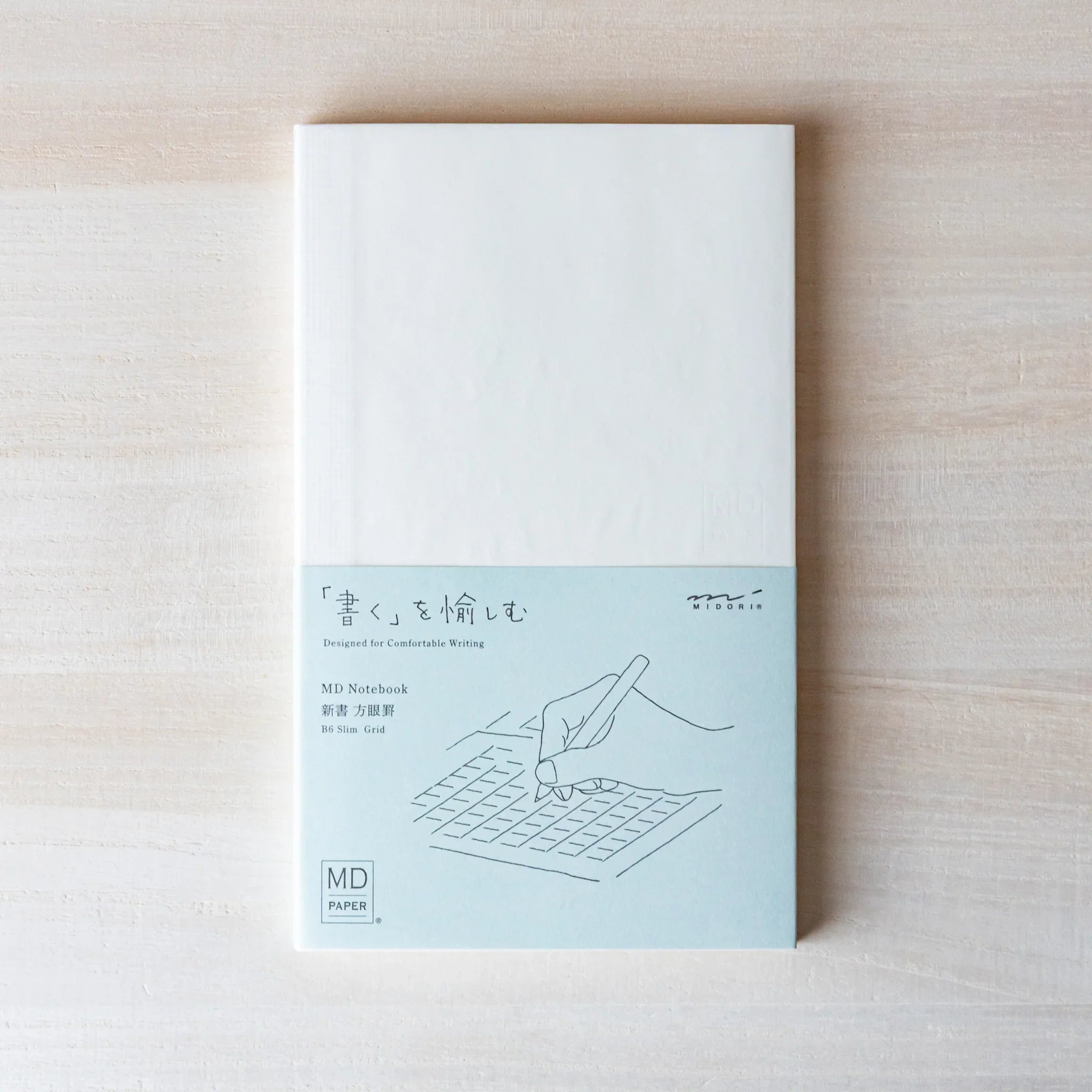 Japanese Notebook view of a Midori MD B6 notebook with grid pages, showing light gray ruling on creamy MD Paper.