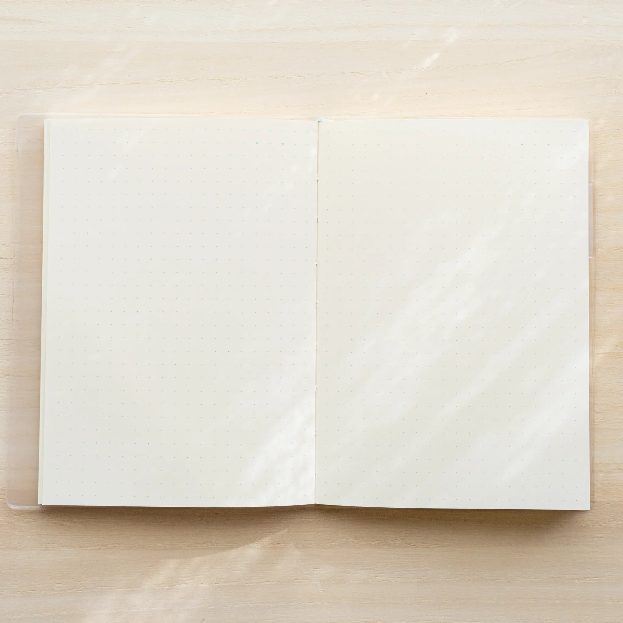 Midori MD Notebook A5 open flat showing blank white spread pages with visible center spine on wooden surface