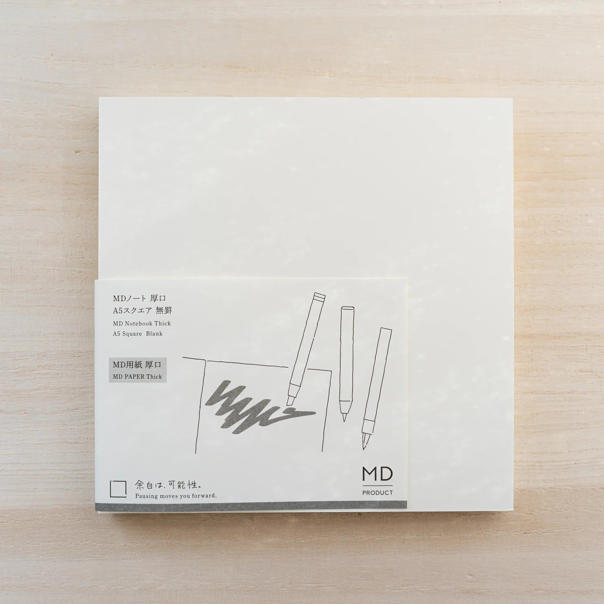 MD Notebook Thick Paper A5 Square in cream cover with paper belly band showing a three-pen line drawing