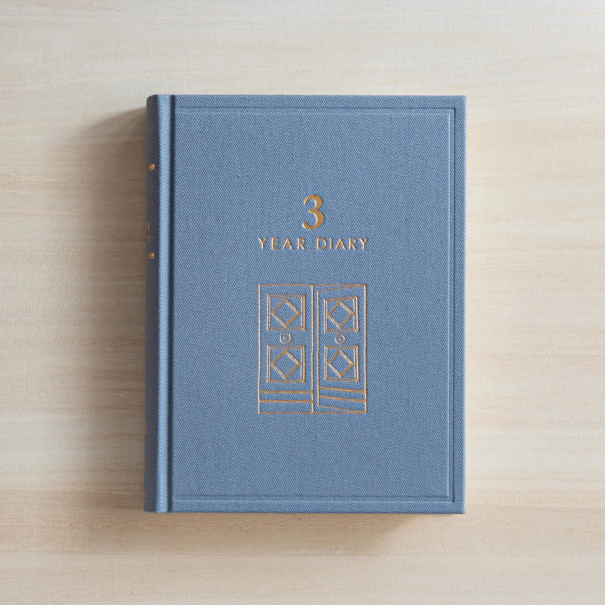 Japanese journal Midori 3-year diary closed gray cover with gold gate motif and 3 Year Diary title, top view