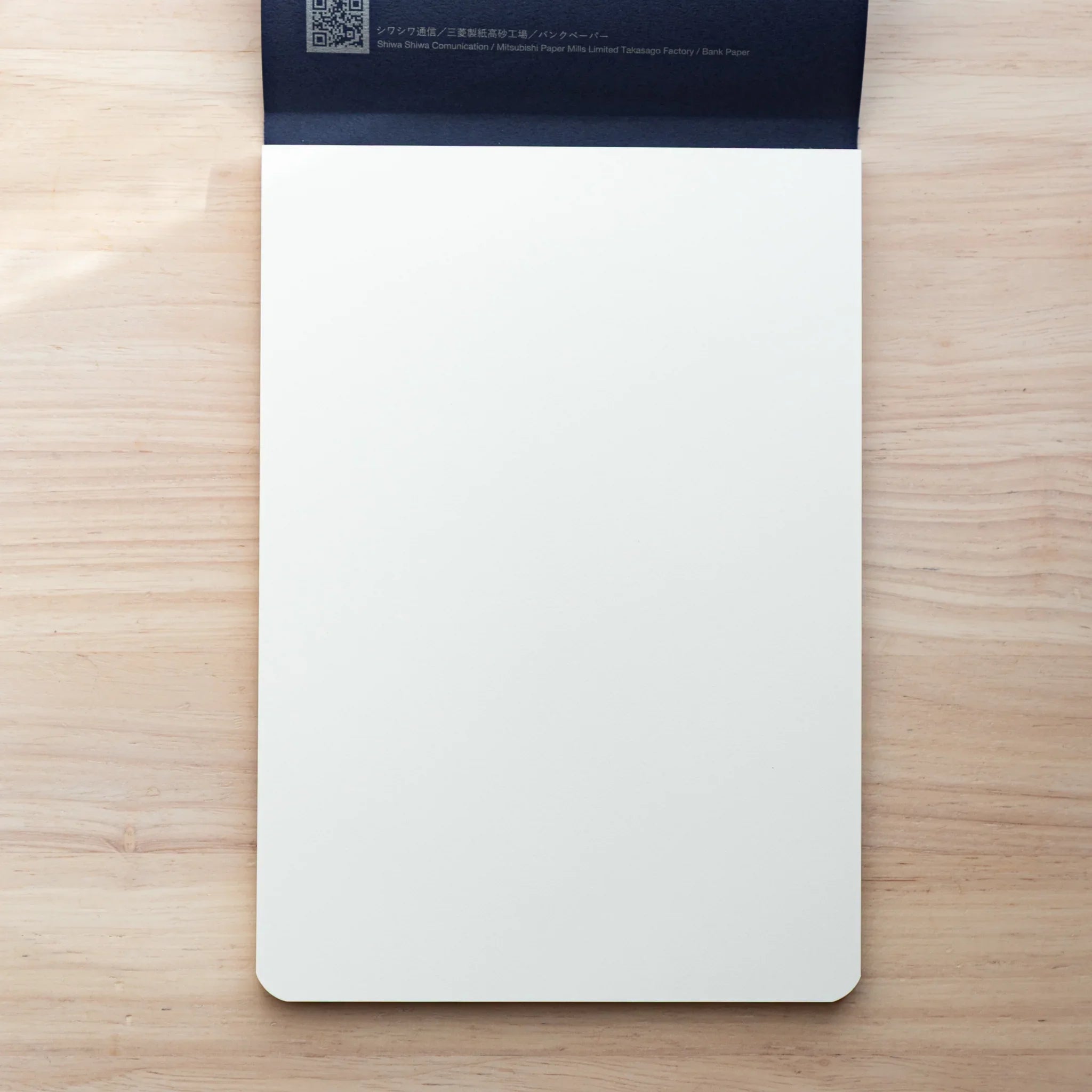 A5 Bank Ledger pad opened displaying horizontal ruled lines and white paper interior pages on wooden surface