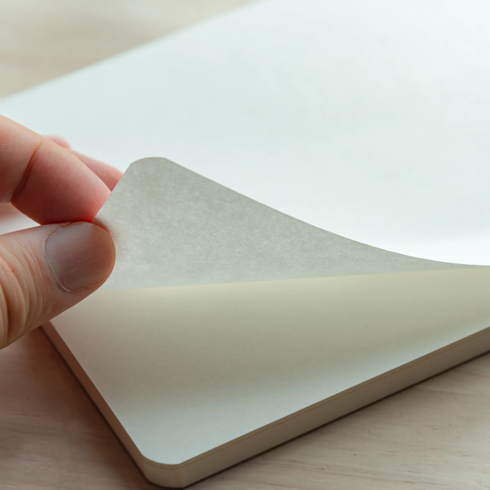 Hand flipping pages of Mitsubishi Bank Ledger A5 pad showing horizontal lines and paper quality during page turn