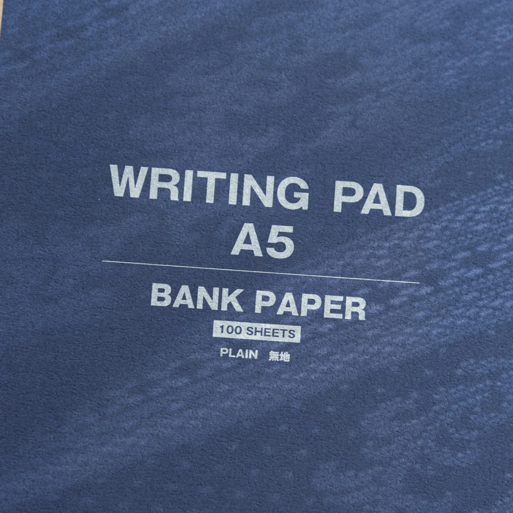 Close-up of navy cover, A5 Japanese Paper Writing Pad, Bank Paper with archival durability, 100 plain sheets inside.
