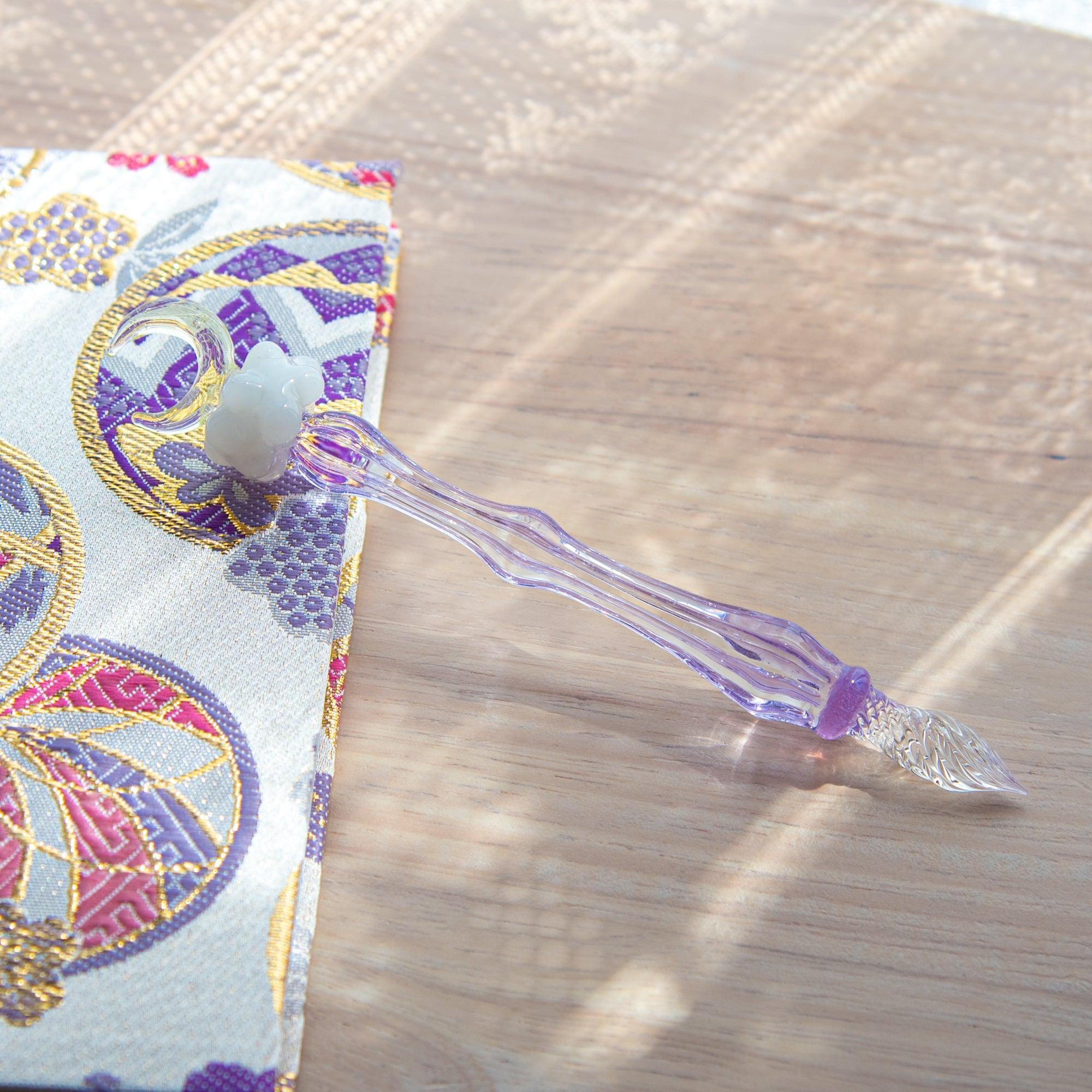 Japanese glass dip pen with white cloud figurine topper on purple glass barrel featuring dip nib and moon accent