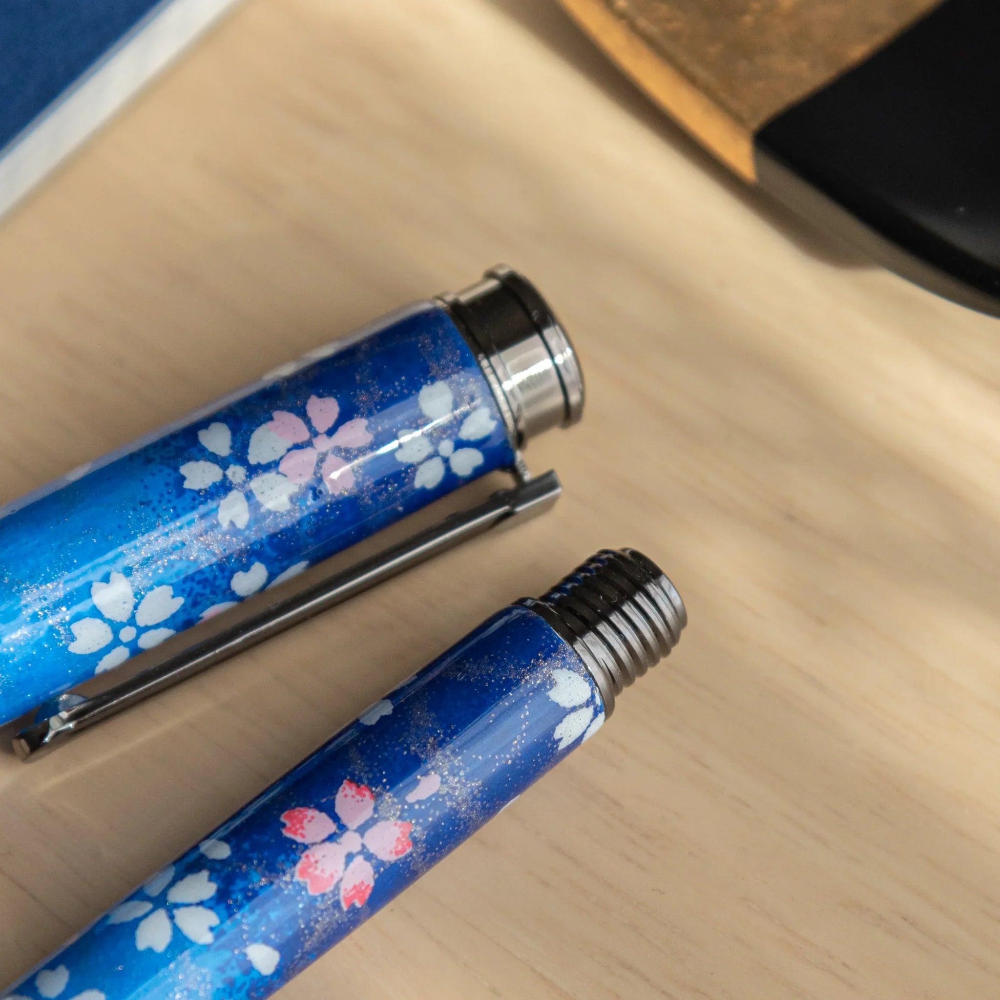 Moonlit Sakura navy Mino washi fountain pen displayed horizontally on neutral beige surface background with nib