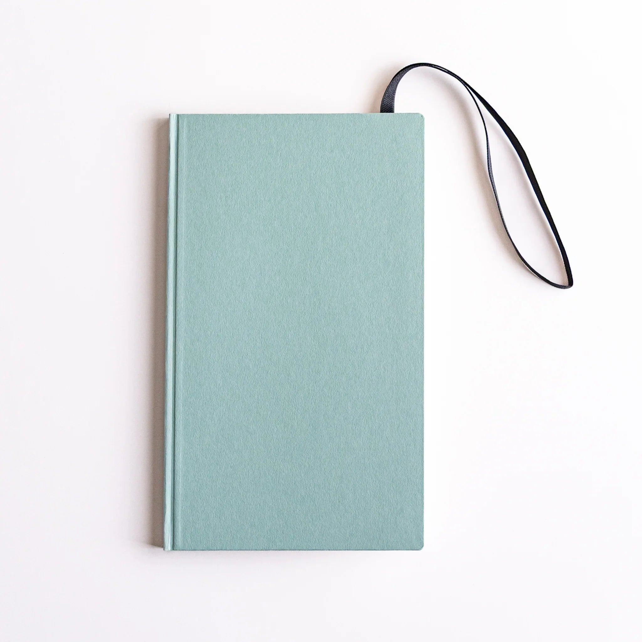 Mint green notebook with navy strap; Dressco B6 multi-use band functioning as closure, bookmark and writing board.