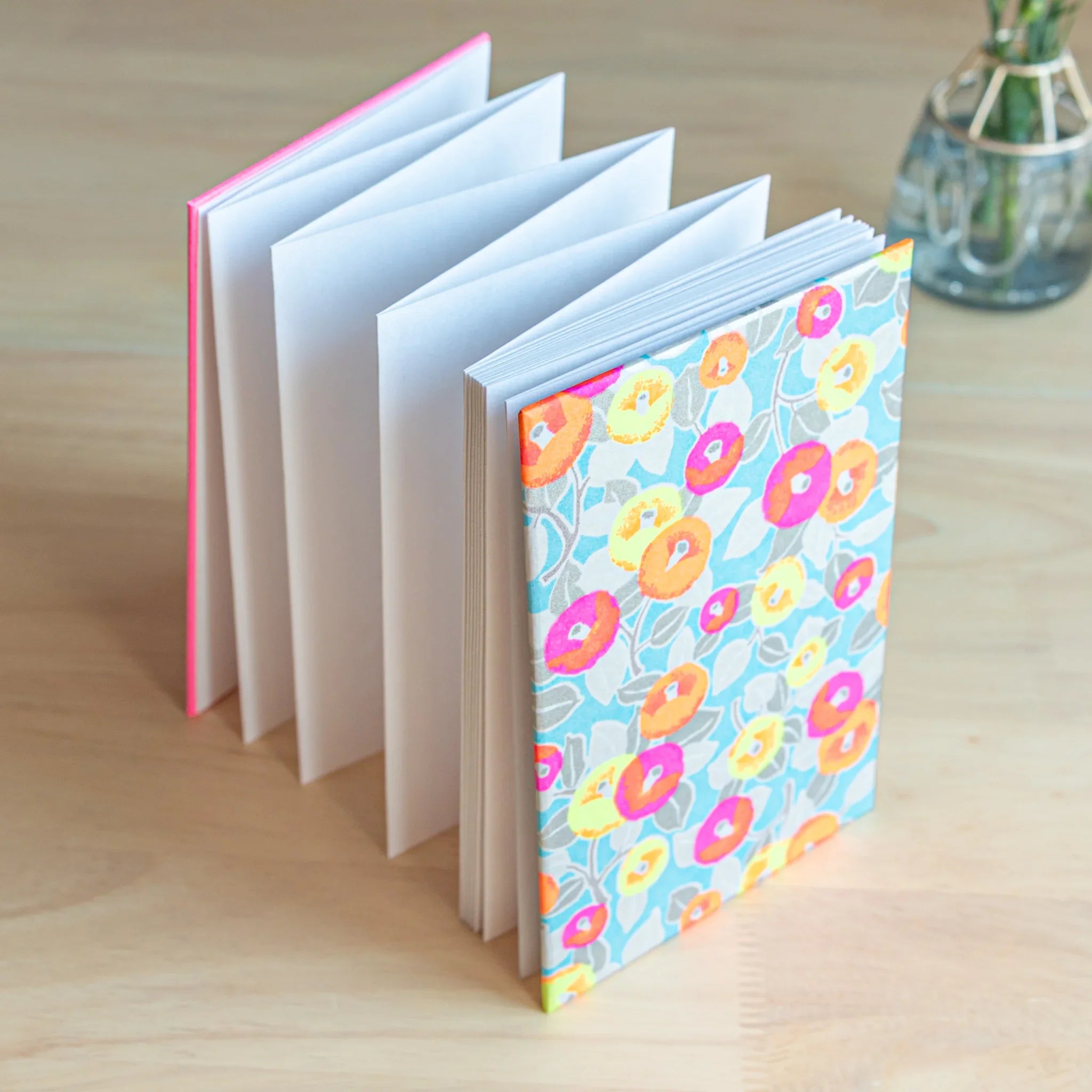 Neon Camellia washi goshuincho stamp book standing upright with accordion fold pages visible and hot pink binding spine