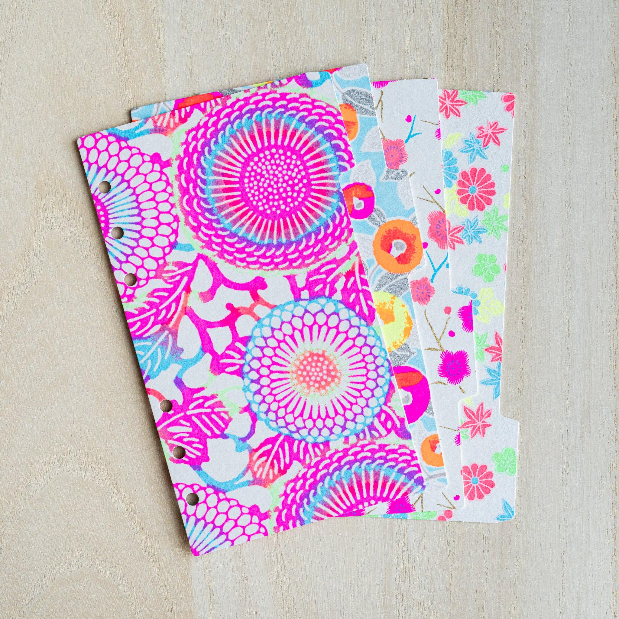 Four neon Yuzen washi index dividers for Bible size planners fanned out, showing staggered side tabs and six holes